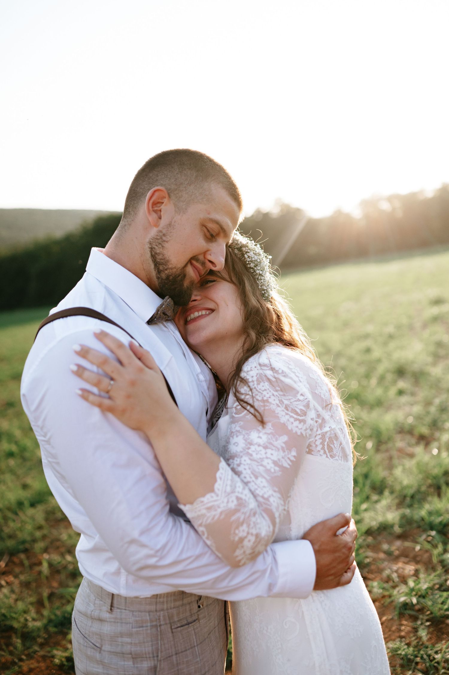 A candid moment of joy between newlyweds laughing together in an outdoor setting.