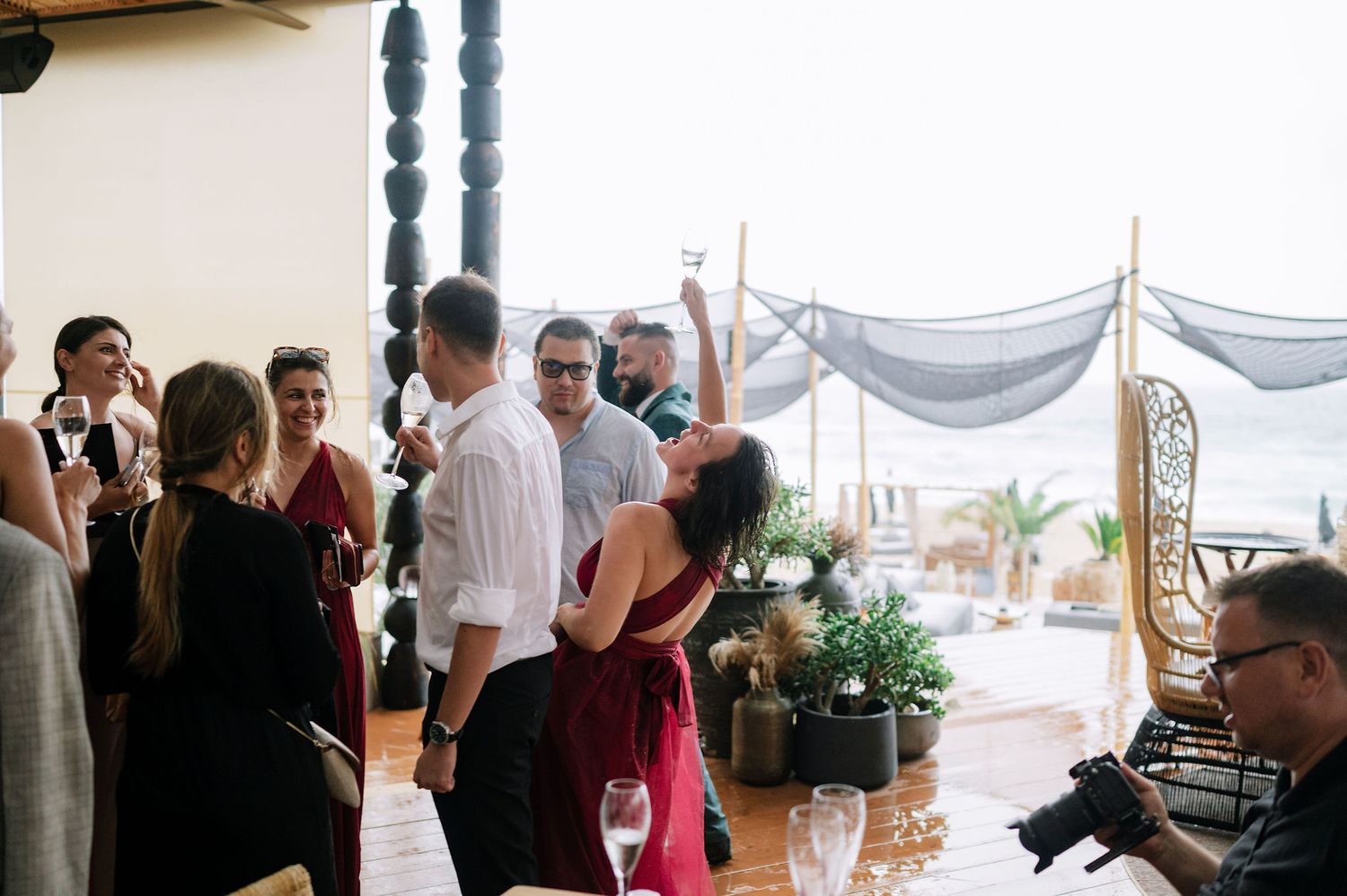 People gathered at a covered outdoor venue with white drapes.