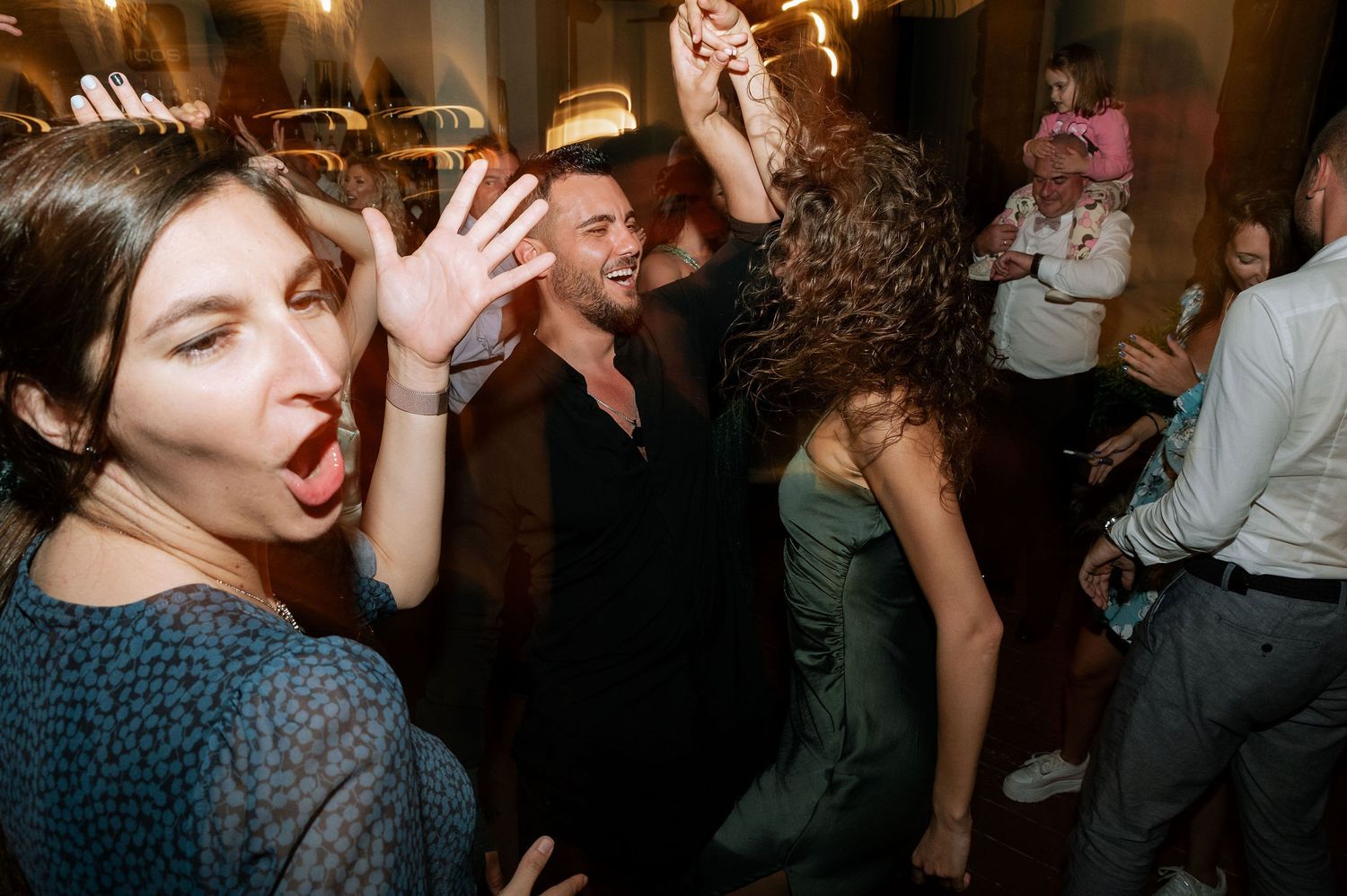 Energetic dance party scene with guests enjoying themselves on a crowded dance floor.