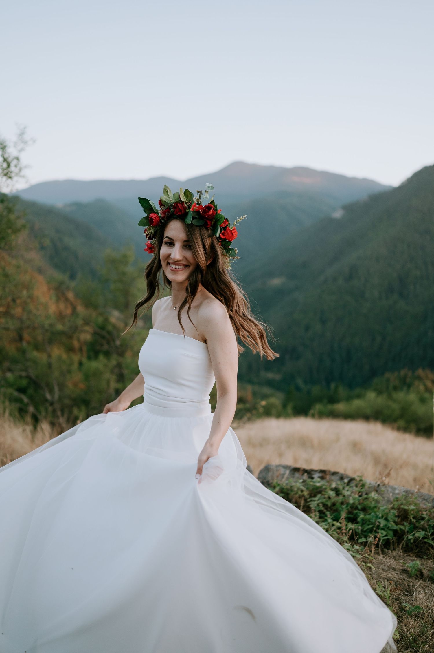 A joyful twirl in a white wedding gown on a scenic mountain vista.
