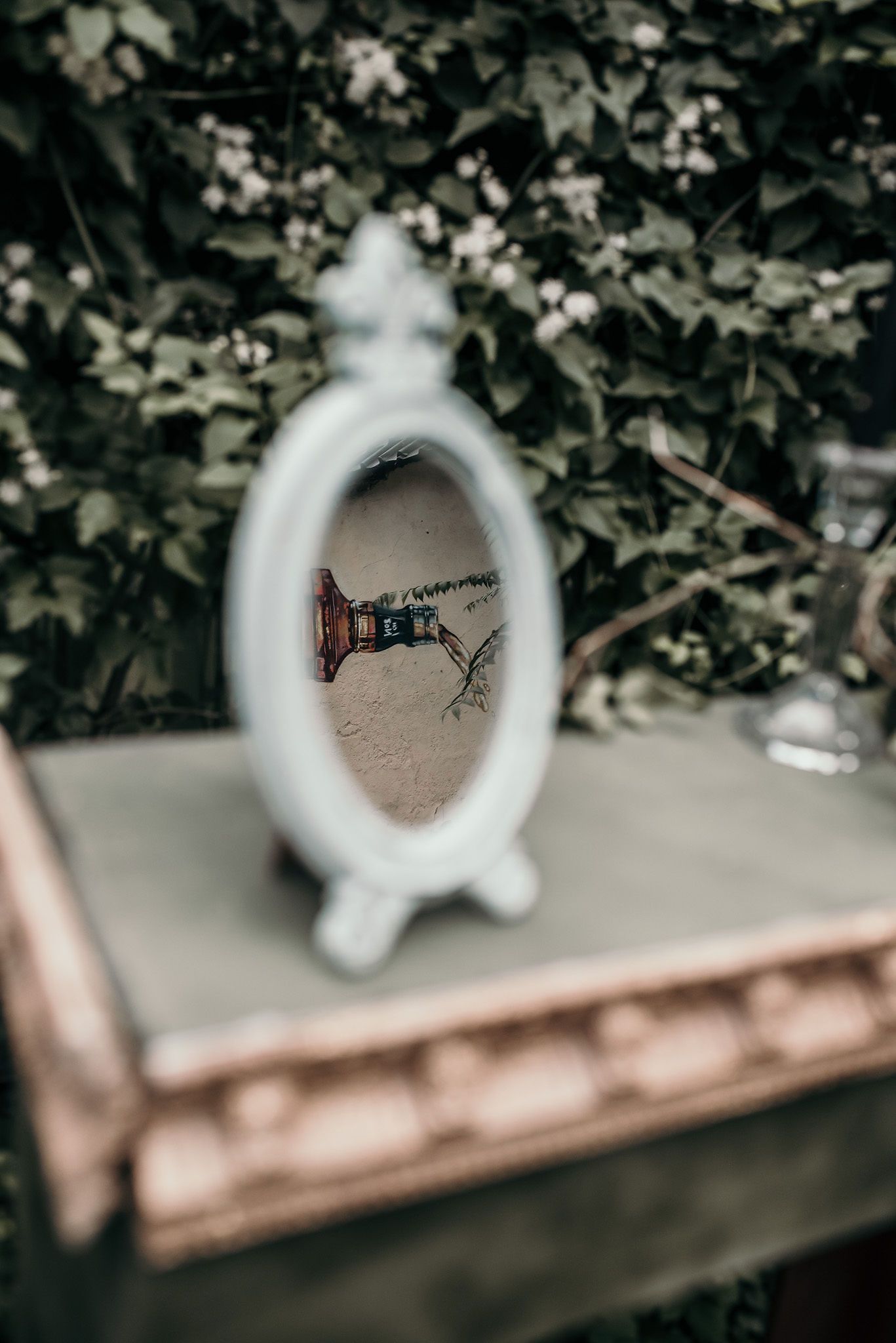 Blurred artistic shot through a white circular frame in garden setting.
