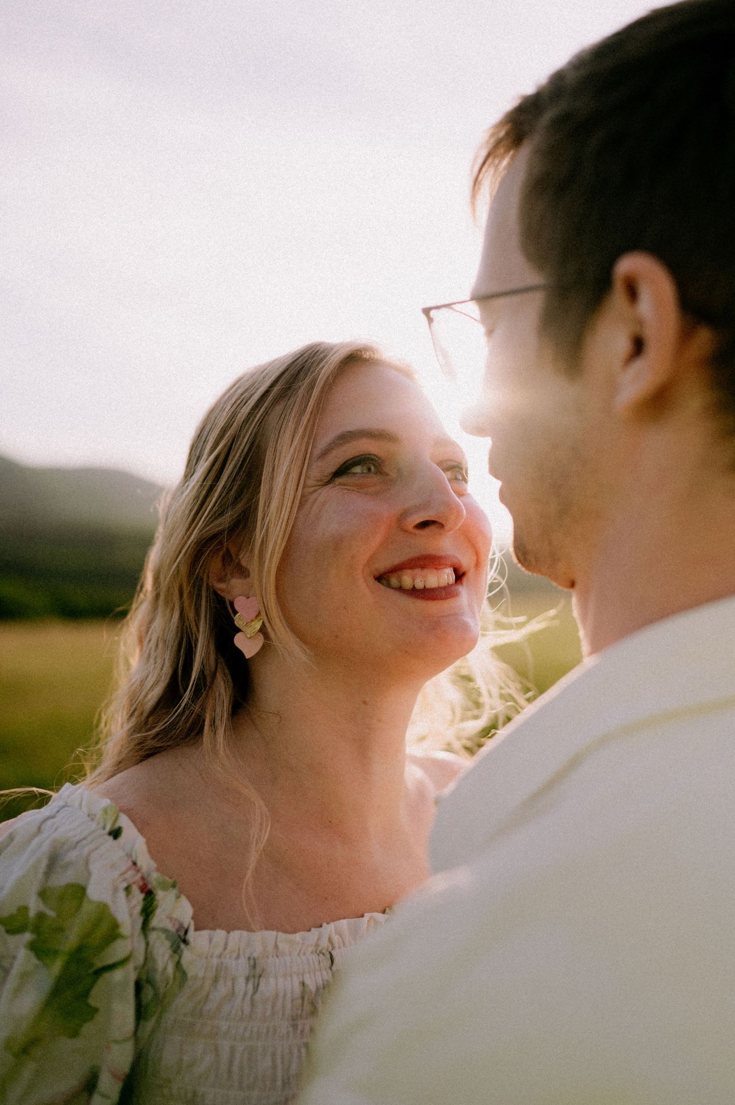 Intimate portrait of couple laughing together in warm sunset light.