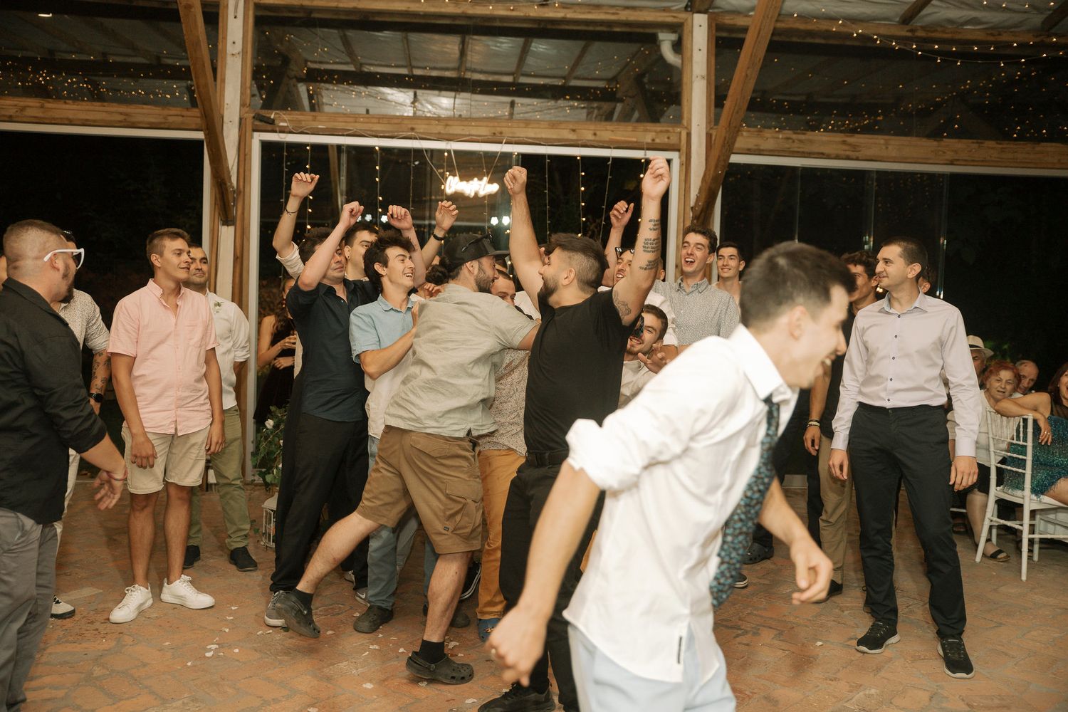 People dancing and having fun at what appears to be a wedding reception or party on a dance floor.