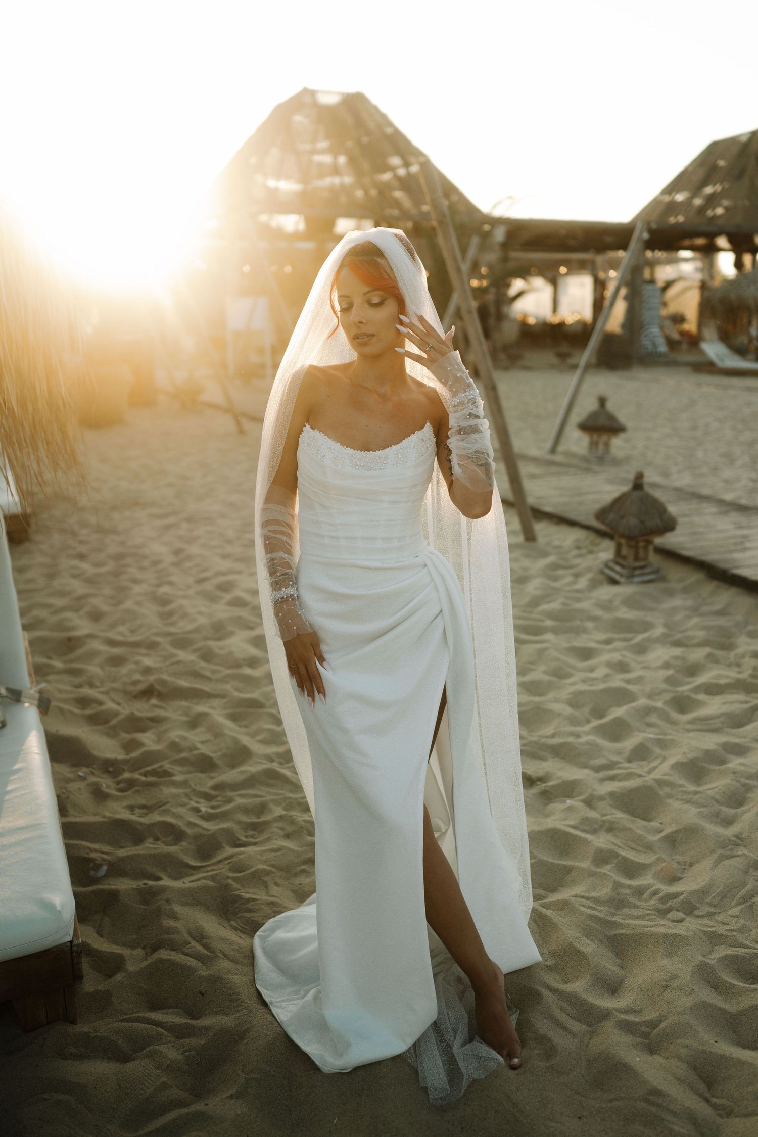 Multiple shots of a person in a white sundress walking on sandy beach during golden hour with sunlight flares.