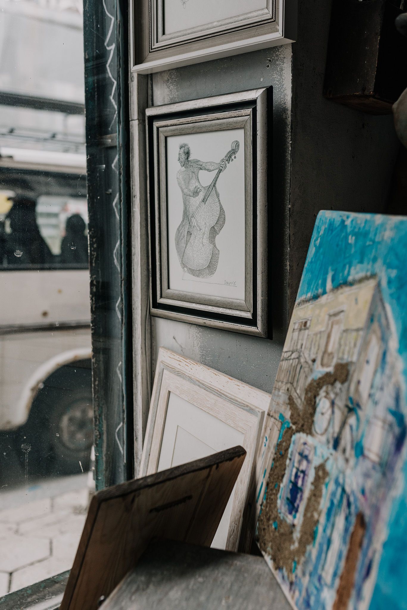 Framed artwork and sketches line the walls of an art studio.