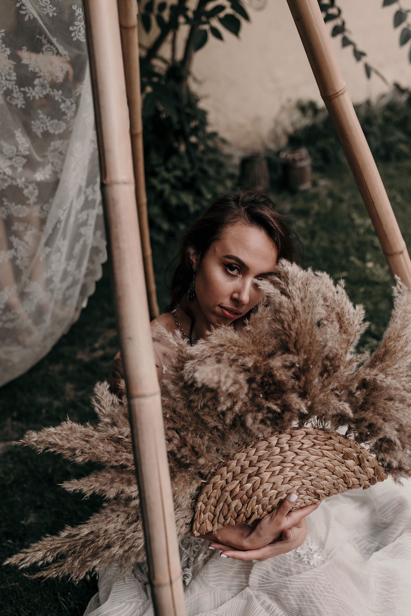 A series of moody photographs showing dried pampas grass bouquets against a rustic backdrop with bamboo elements.