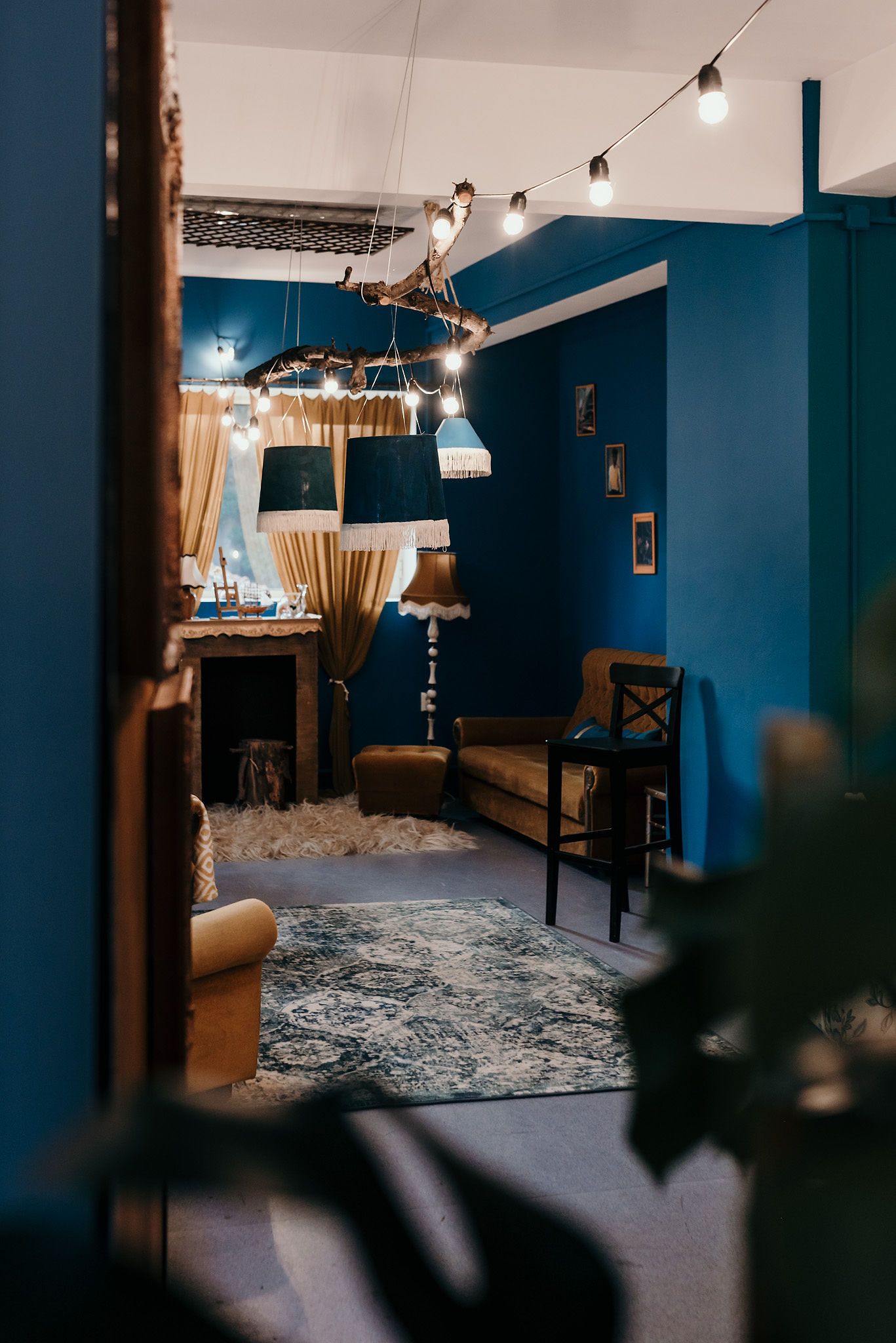 Modern room with blue walls, string lights, and elegant furniture.