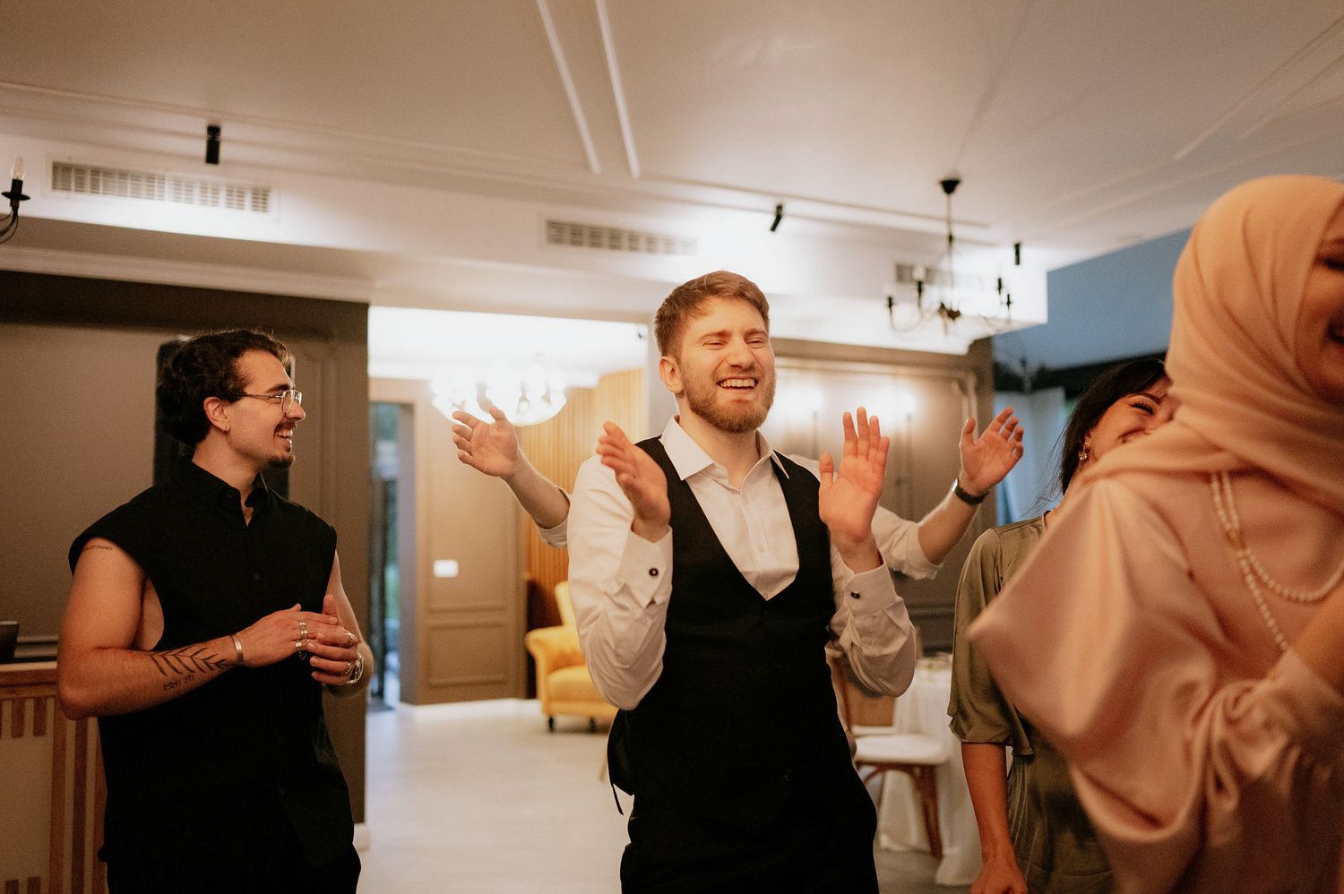 Group of party guests enjoying themselves in a brightly lit indoor space.