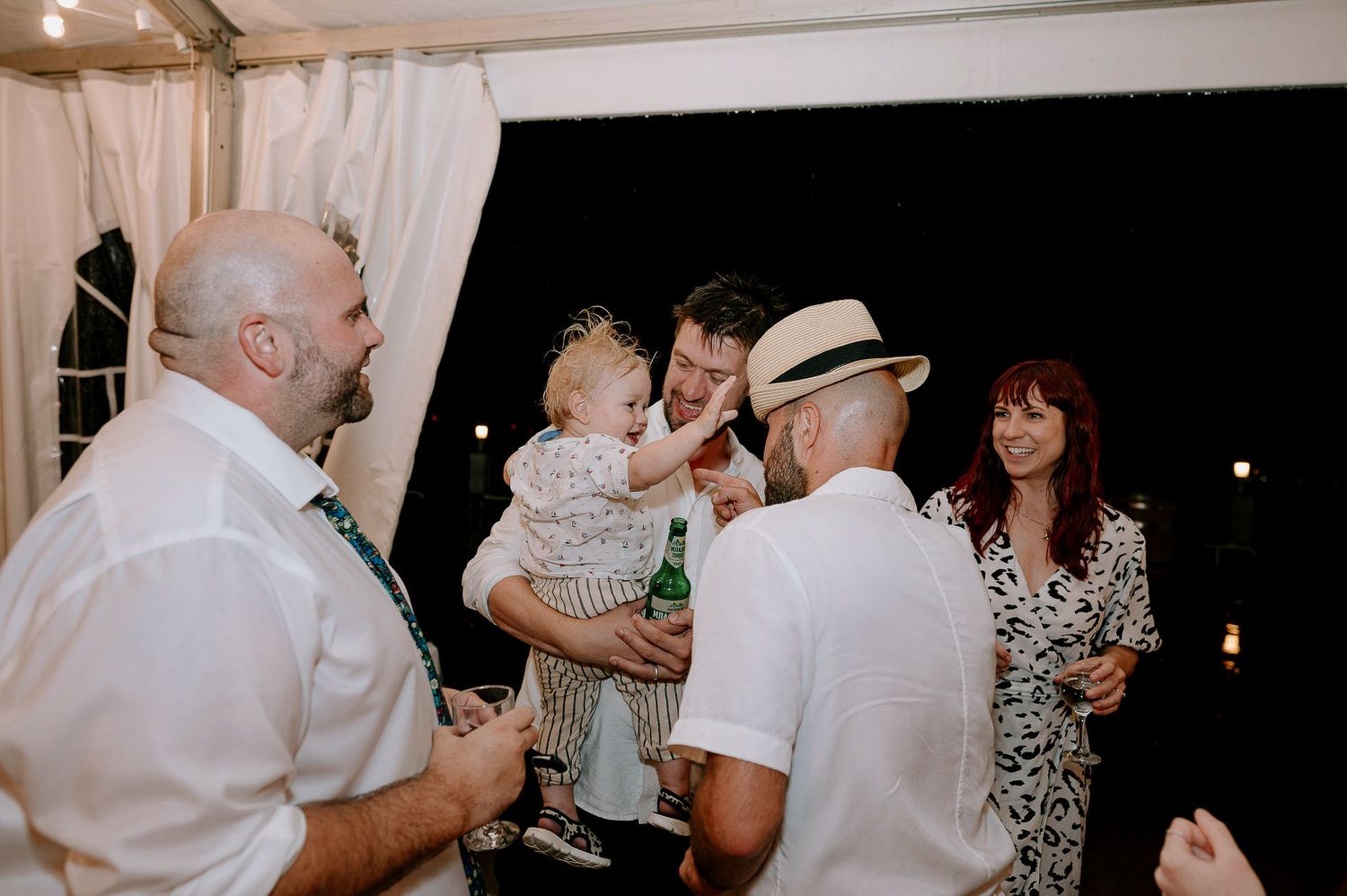 Guests enjoying a lively dance party at an indoor wedding reception.