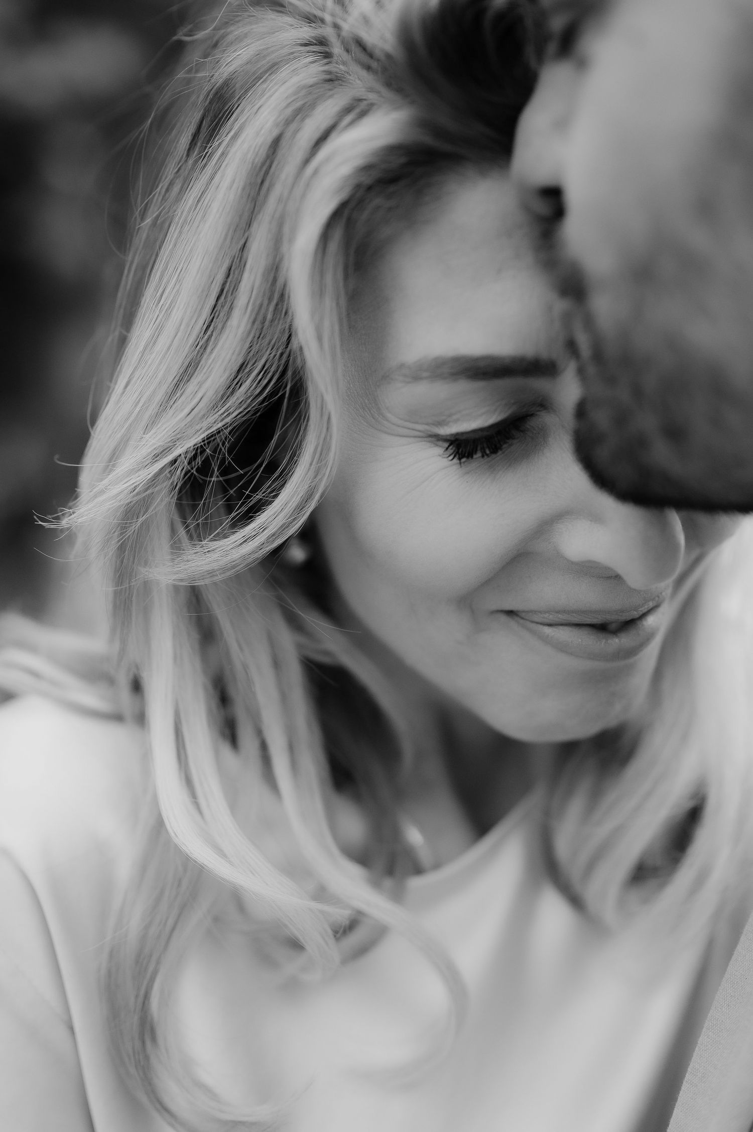 Close-up black and white portraits showing tender expressions and blonde hair.