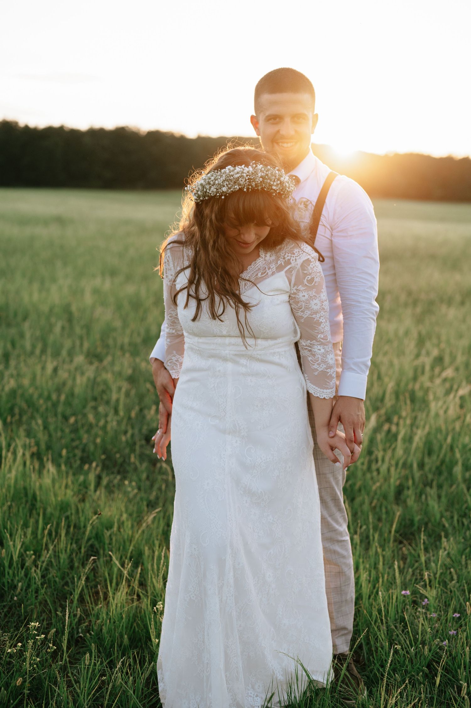 A romantic sunset portrait in a meadow with golden light streaming through.