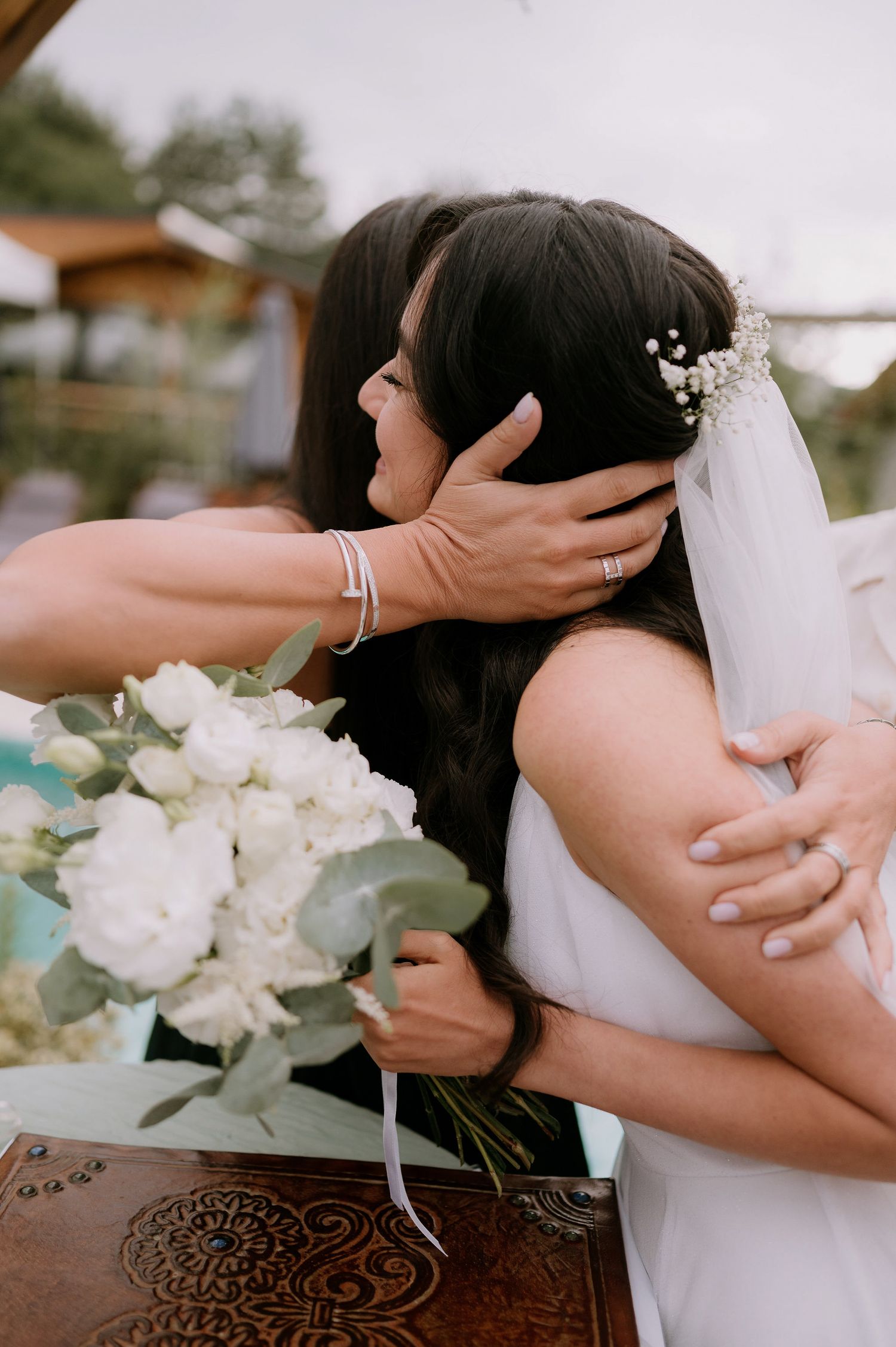 Intimate wedding details with white flowers and delicate hair accessories.