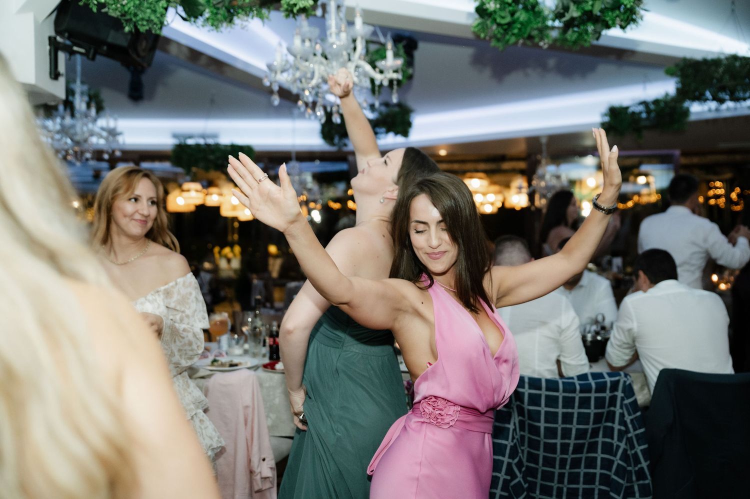 People dancing and celebrating together at a lively wedding reception party on the dance floor.