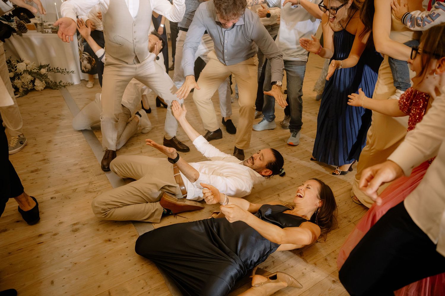Guests dancing energetically on the floor at a lively wedding reception party indoors.