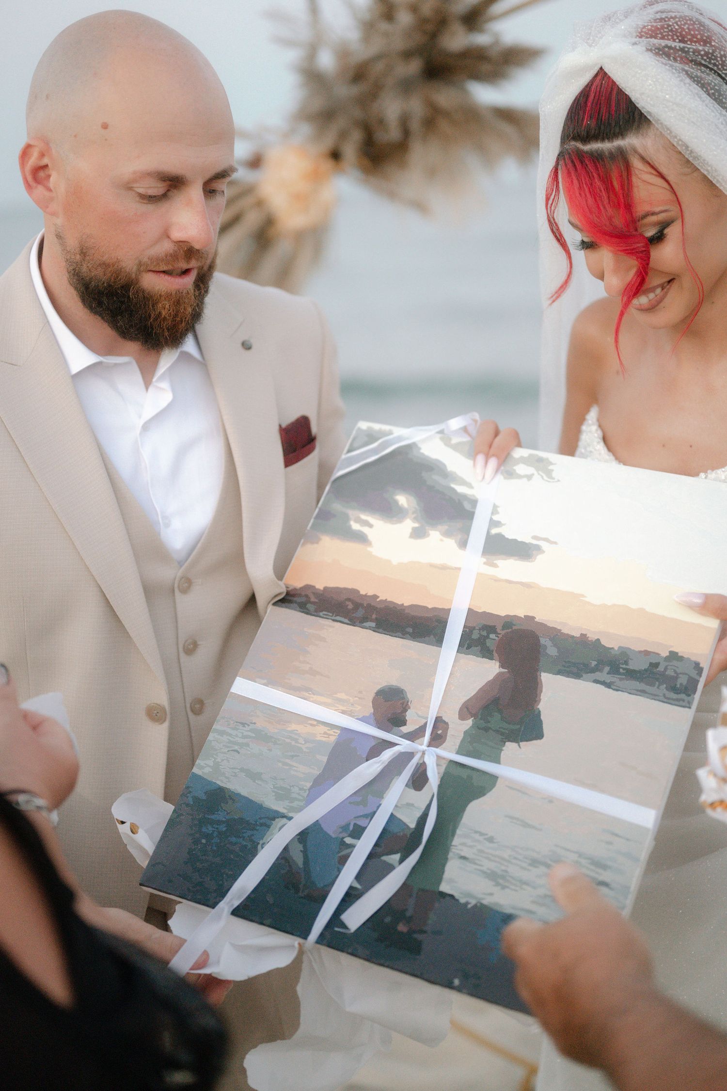 A series of photos showing a couple opening and reading a letter together on a beach at sunset.