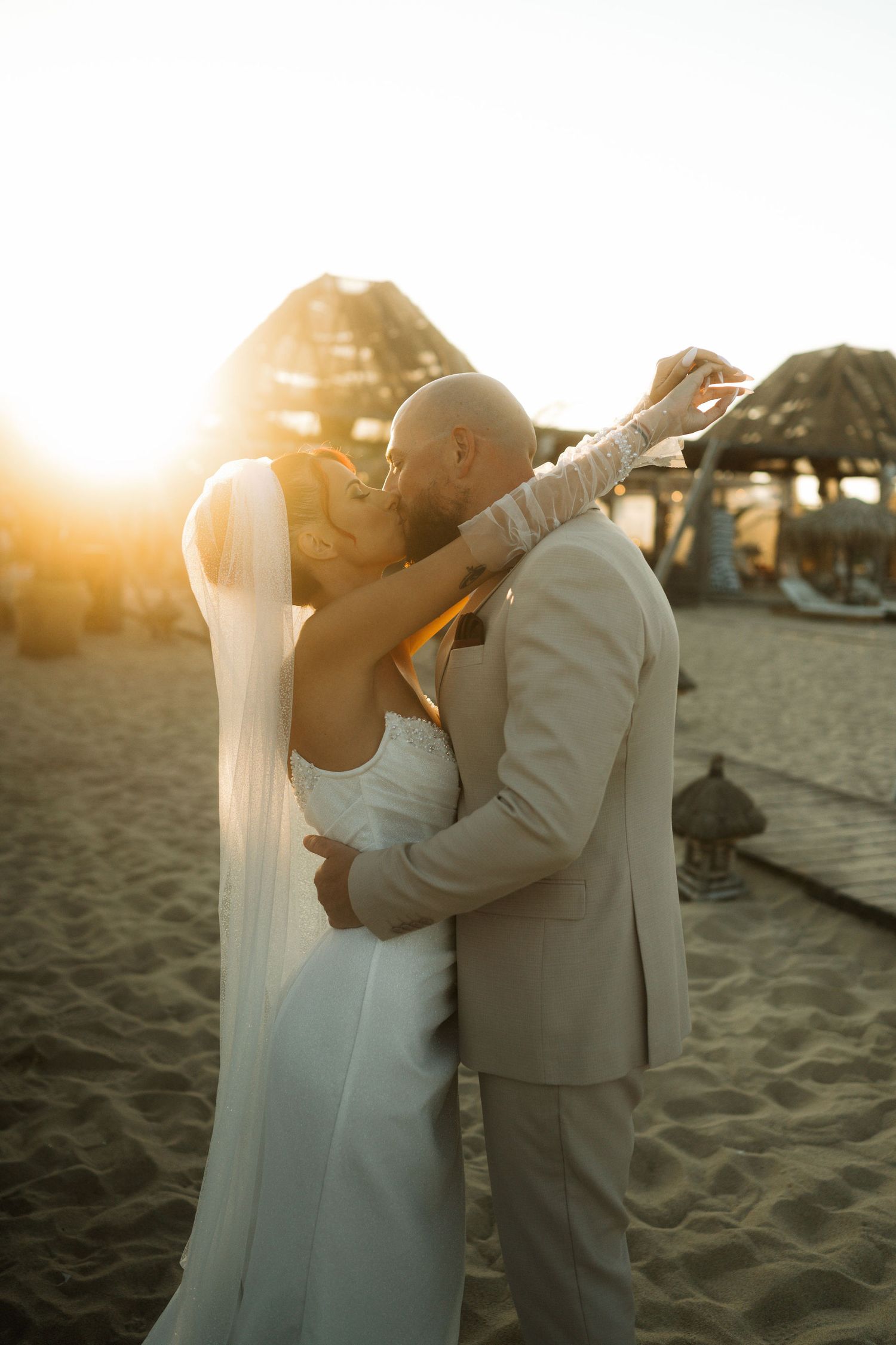 A romantic couple embraces on a sandy beach at sunset creating a series of silhouetted moments.