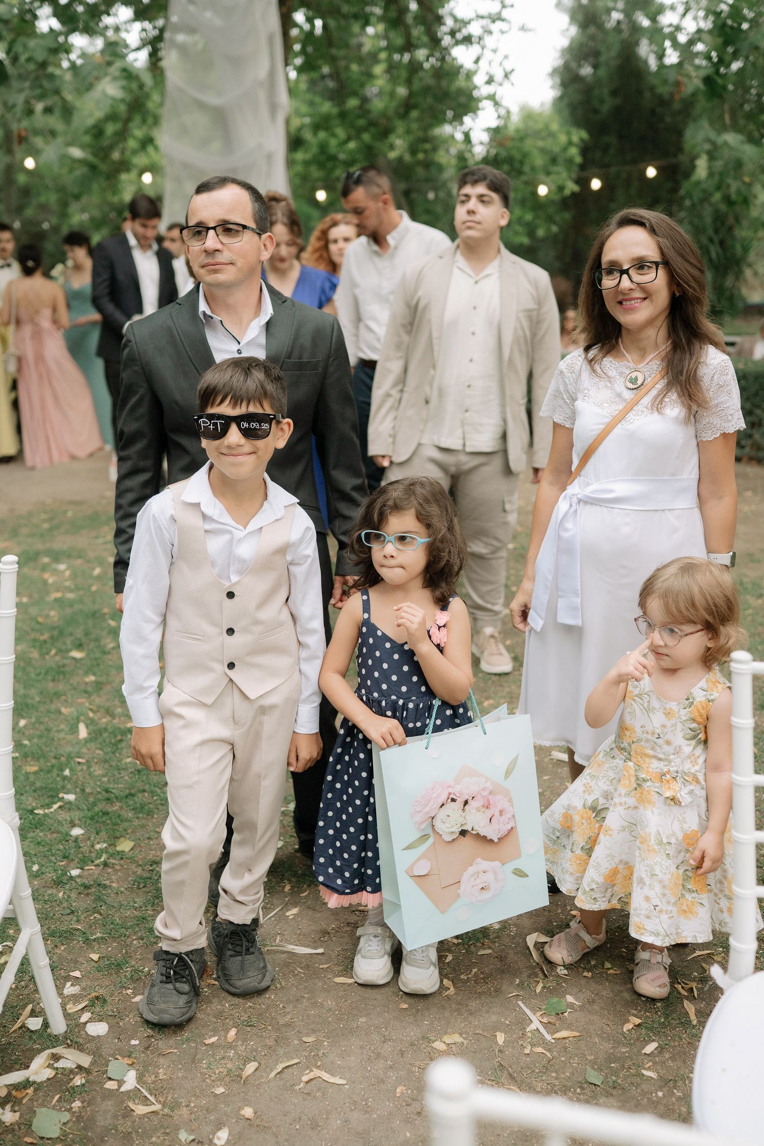 A series of candid outdoor wedding photos showing guests in casual summer attire gathered in a garden setting.