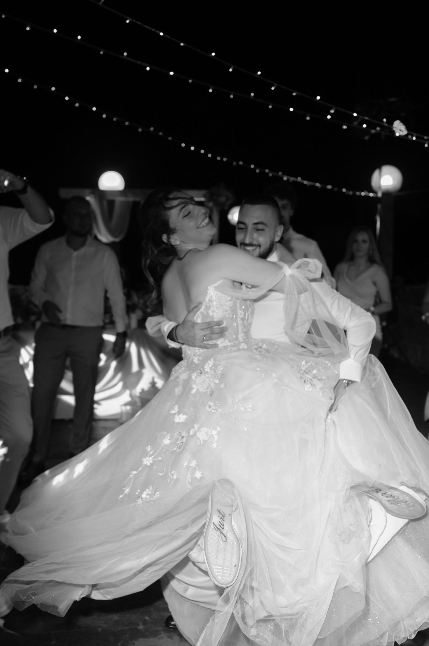 Black and white photos of wedding reception dancing with flowing white dresses creating motion blur effects.