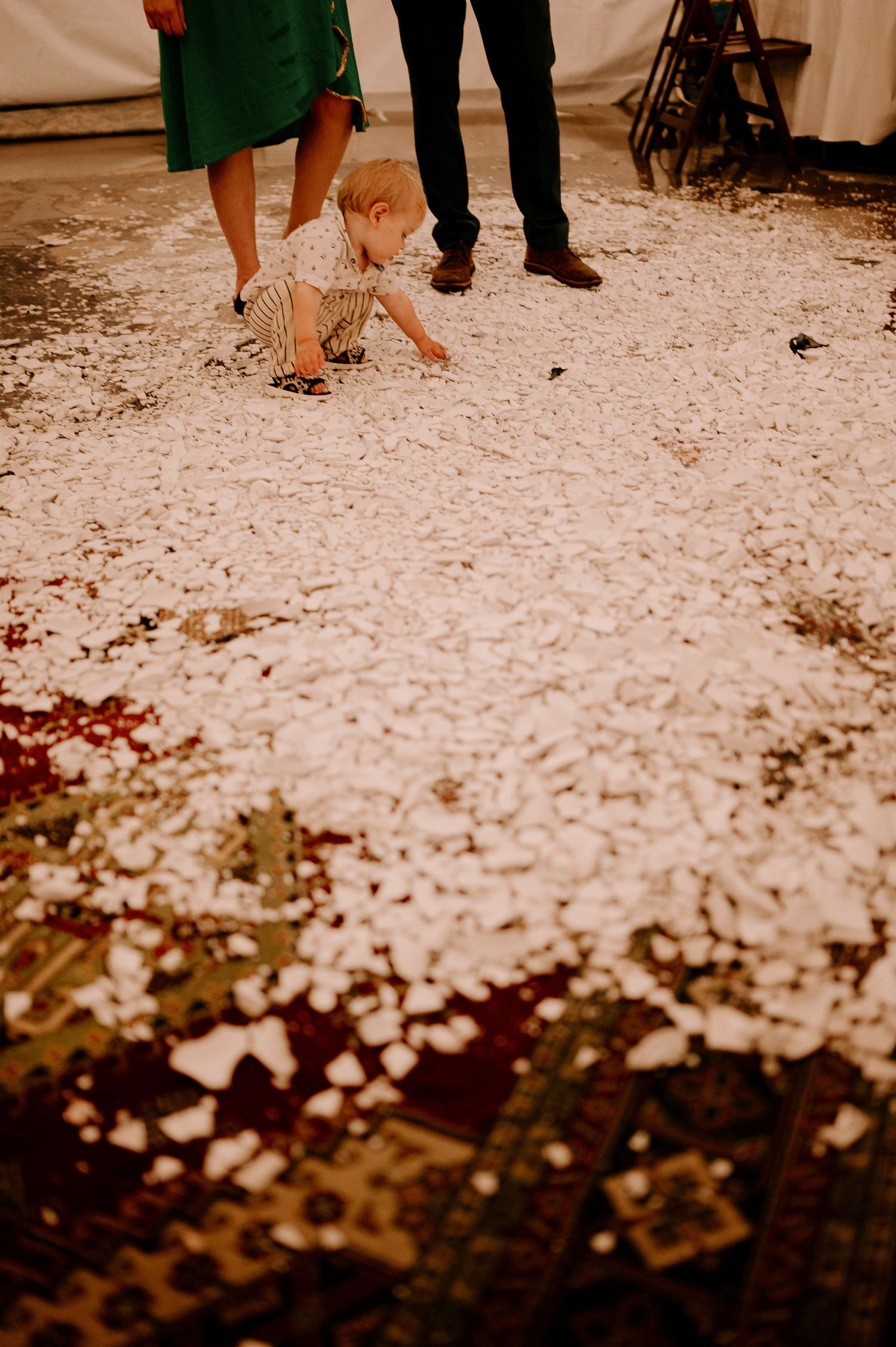 White confetti scattered across a dark floor at a wedding reception.