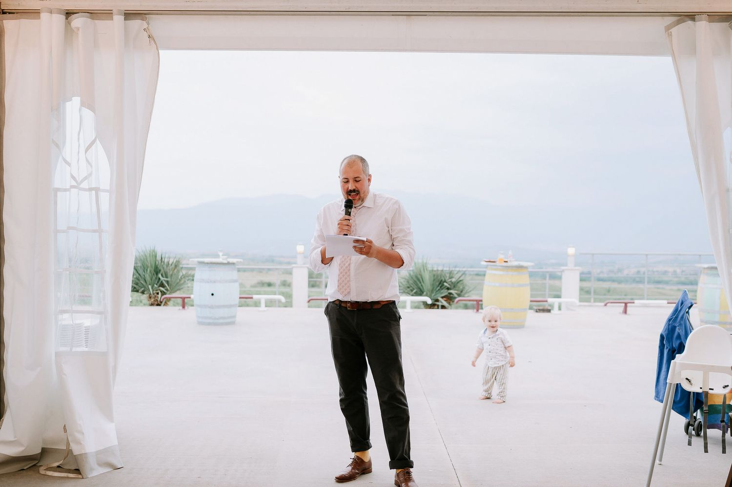 Bright and airy wedding venue with white drapes and scenic mountain views in the background.