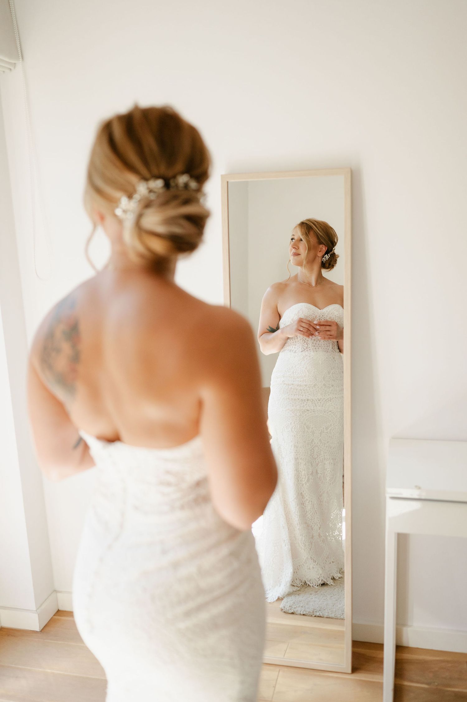 Multiple views of a strapless wedding dress being showcased in a sunlit room with mirrors.