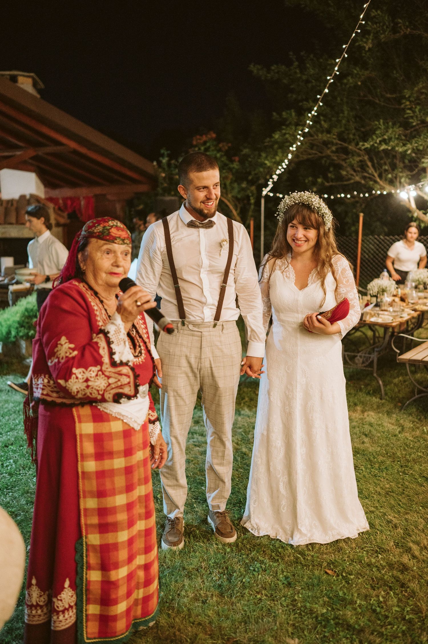 Wedding celebration featuring traditional folk elements and string lights at dusk.