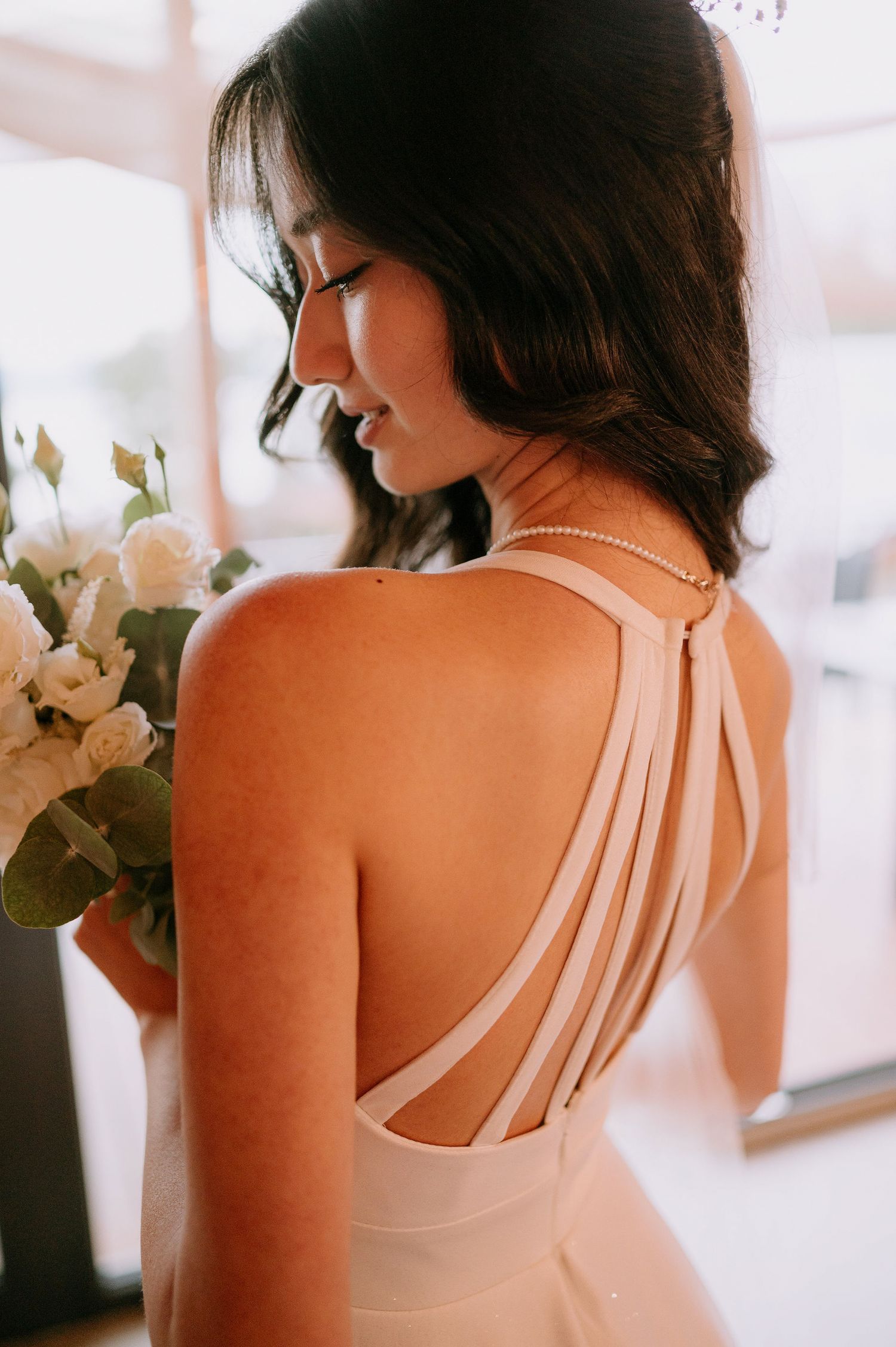 Back detail of a white wedding dress showing multiple elegant straps.