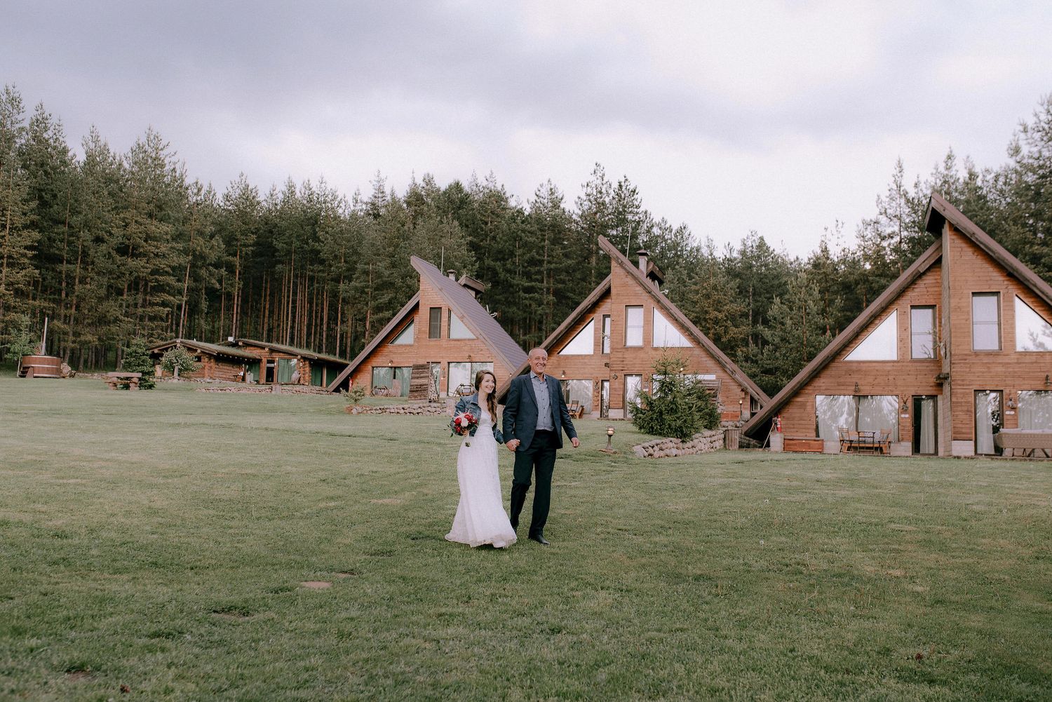 A-frame cabins line the edge of a grassy field during an outdoor celebration.