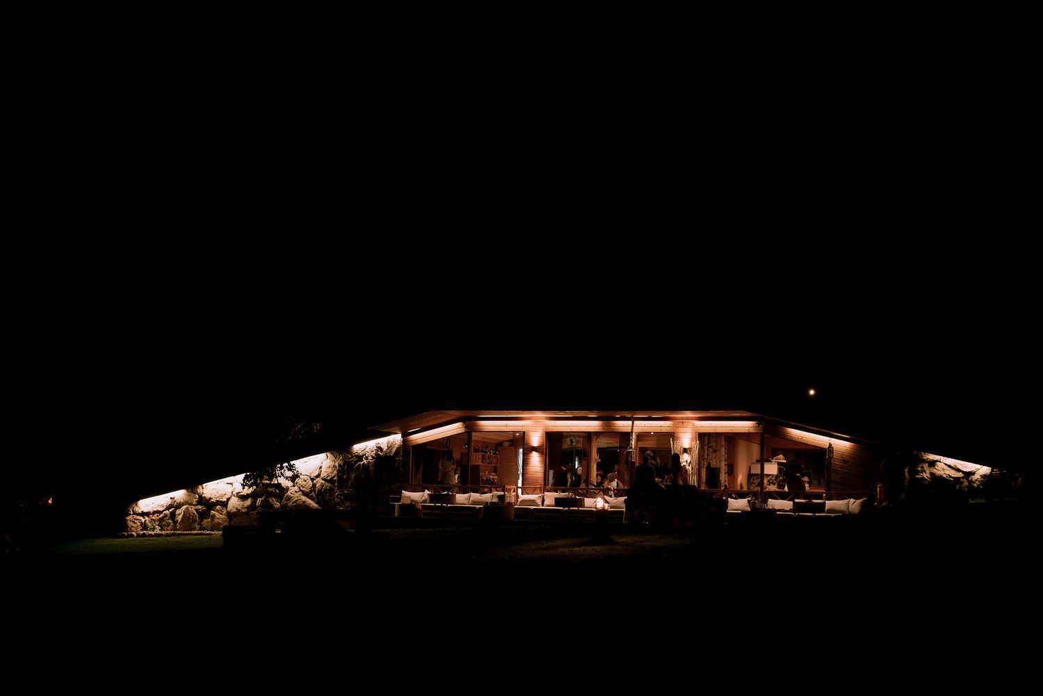 Illuminated event venue buildings glowing warmly against the dark night sky.