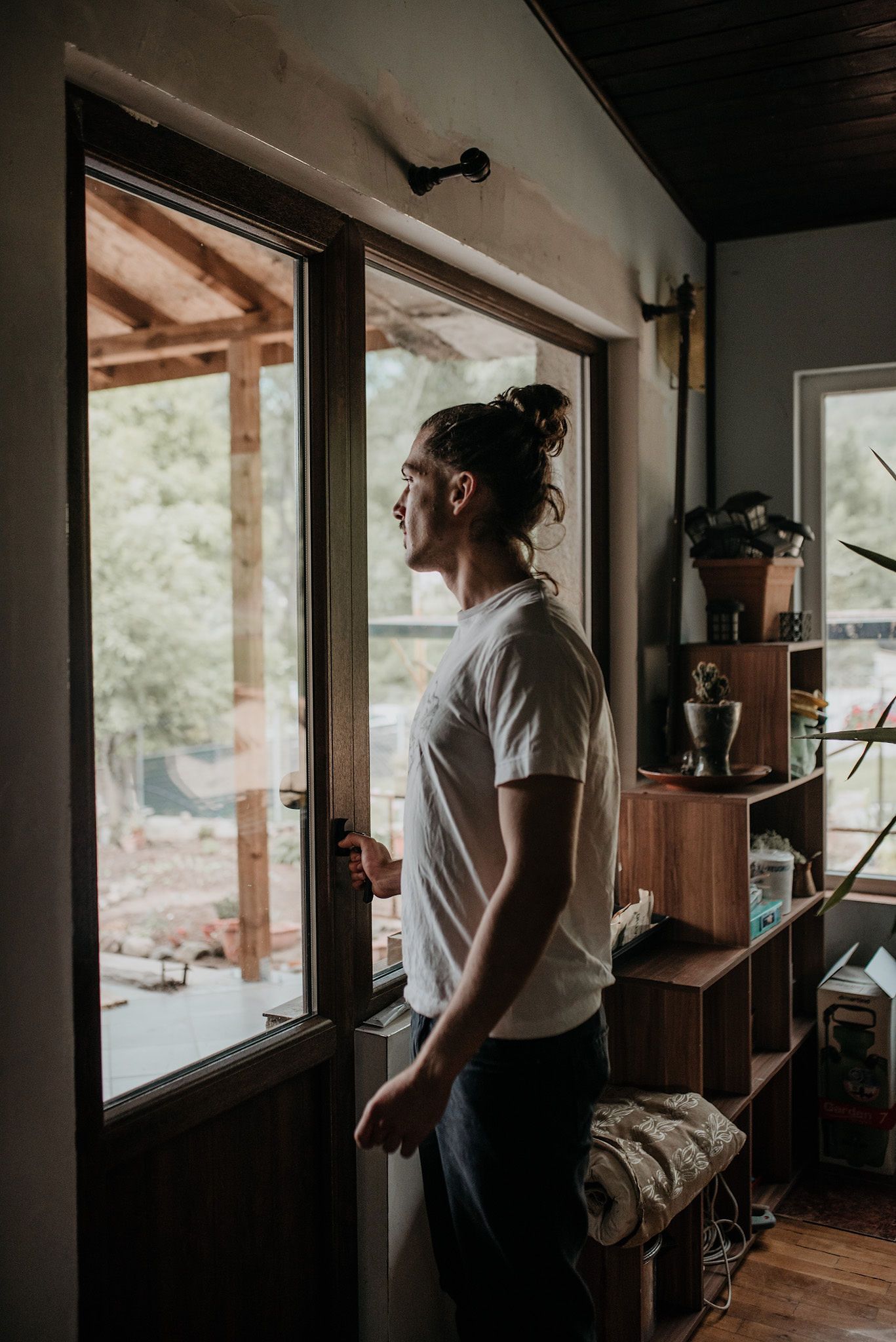 A series of four photos showing someone looking out large windows in a rustic cabin interior.