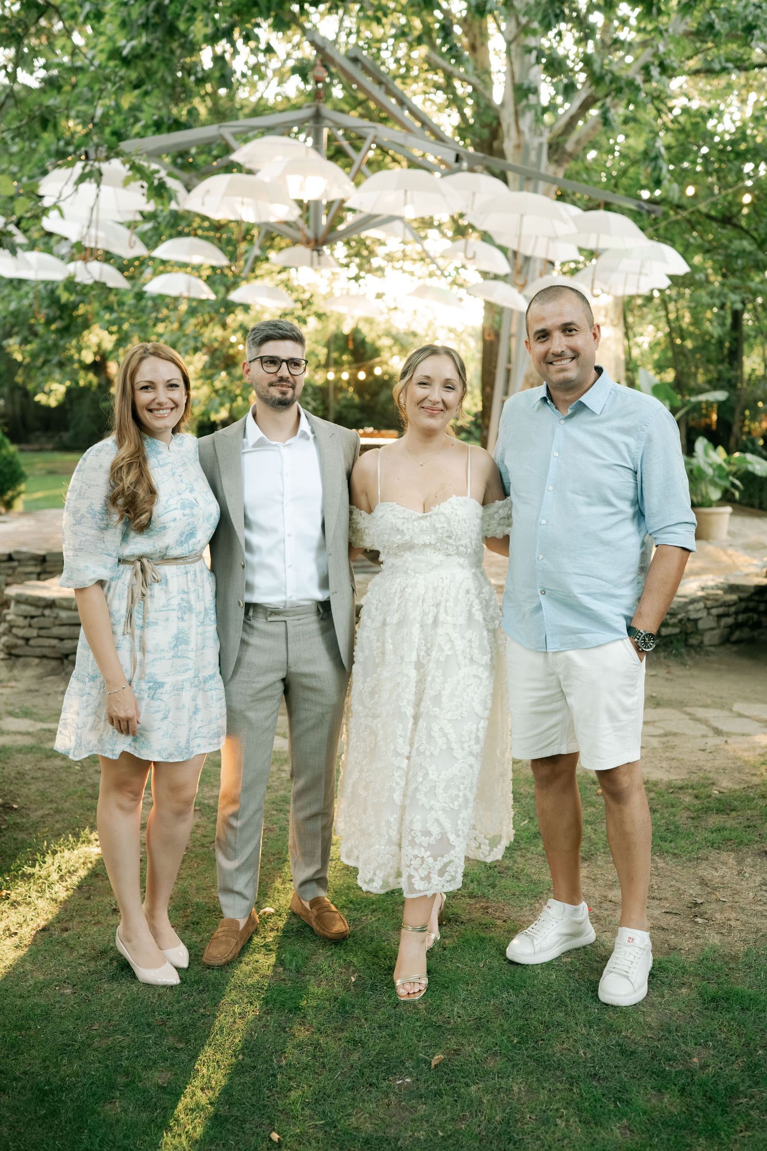 Group photo series in a garden setting showing coordinated casual summer outfits in white and neutral tones.