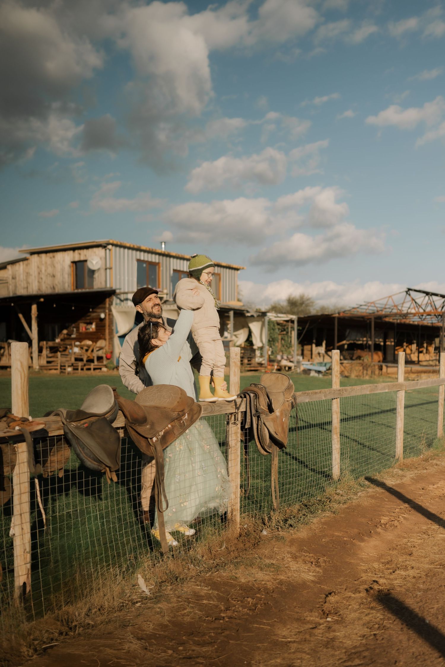 A series of vintage photographs showing people leaning on a wire fence in a rural farm setting under cloudy skies.