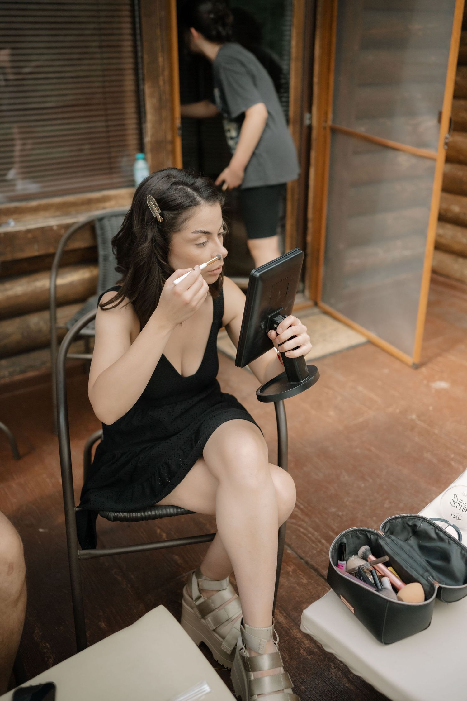 A sequence of photos showing someone in black clothing sitting and stretching on a covered porch.