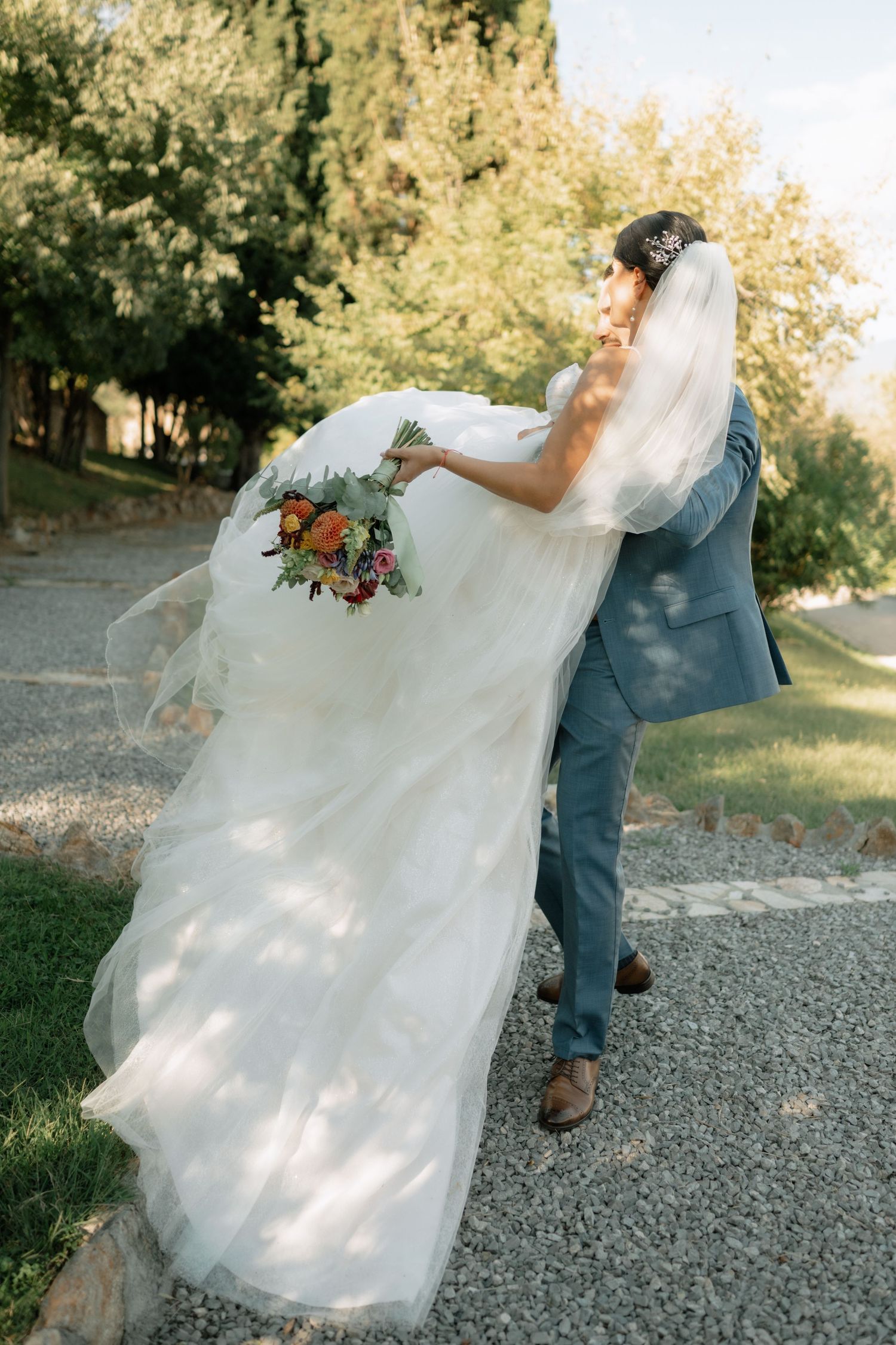 A sequence of wedding photos showing a flowing white dress twirling gracefully on a gravel path in golden sunlight.