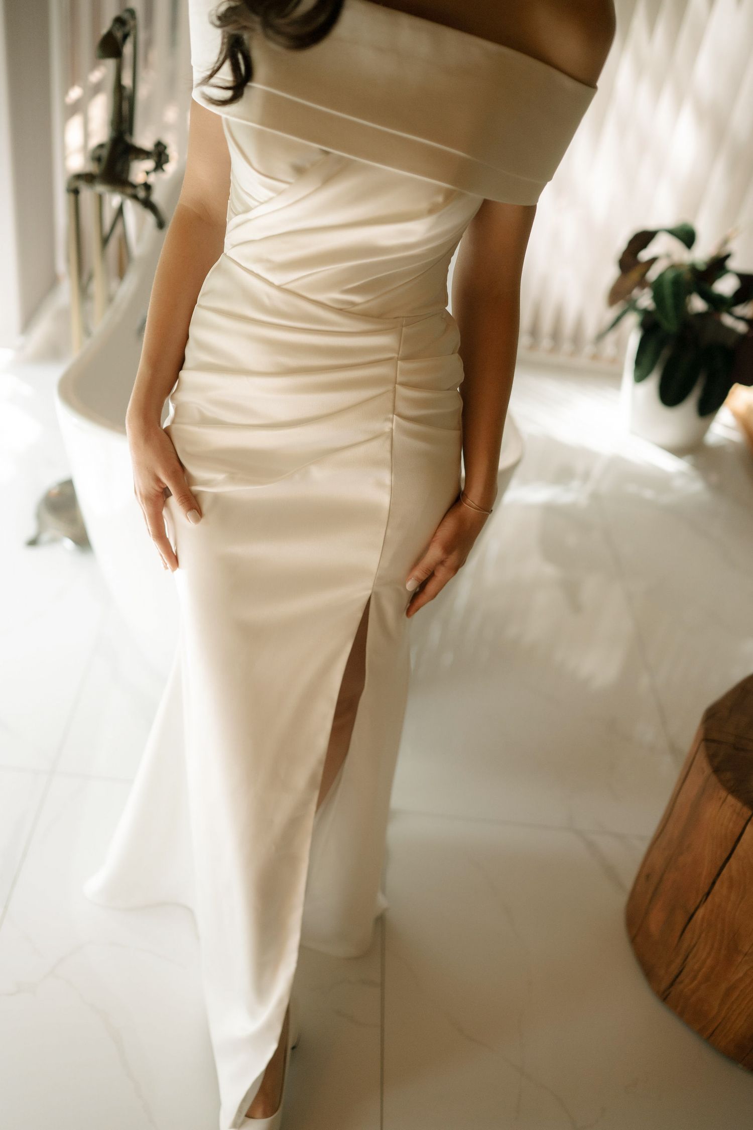 Elegant white satin wedding dress with side slit detail shown from multiple angles in bright natural lighting.