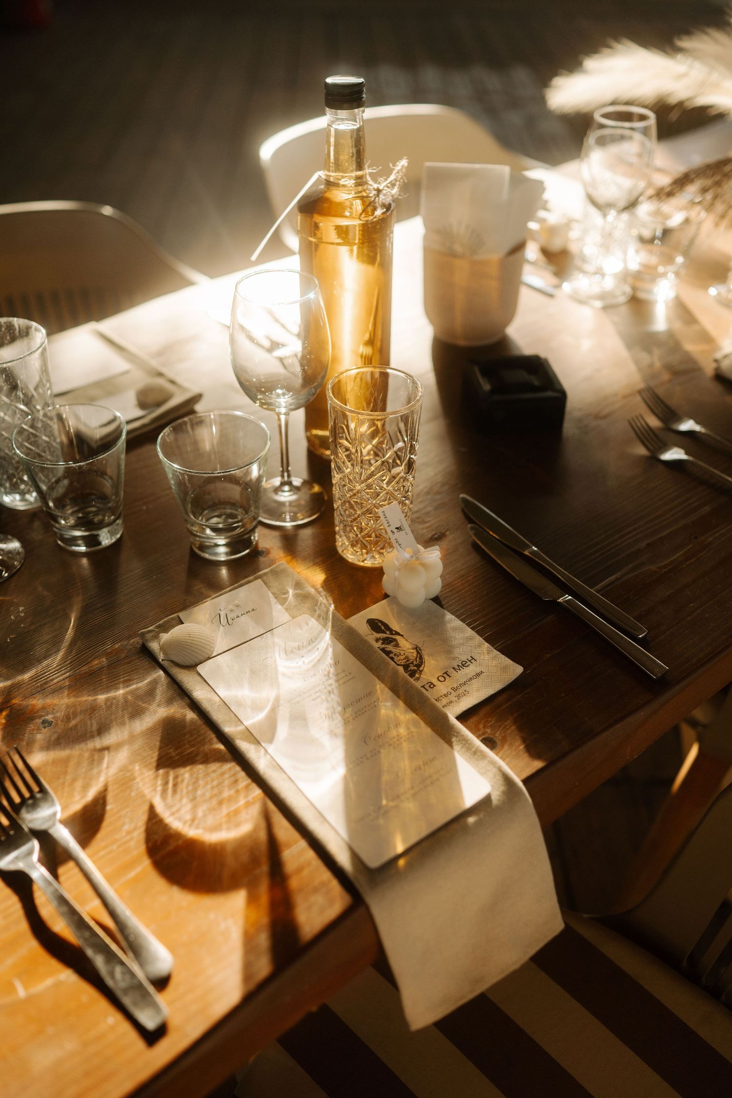 Elegant table settings with glowing amber lighting cast shadows across wine glasses and place settings at a restaurant.