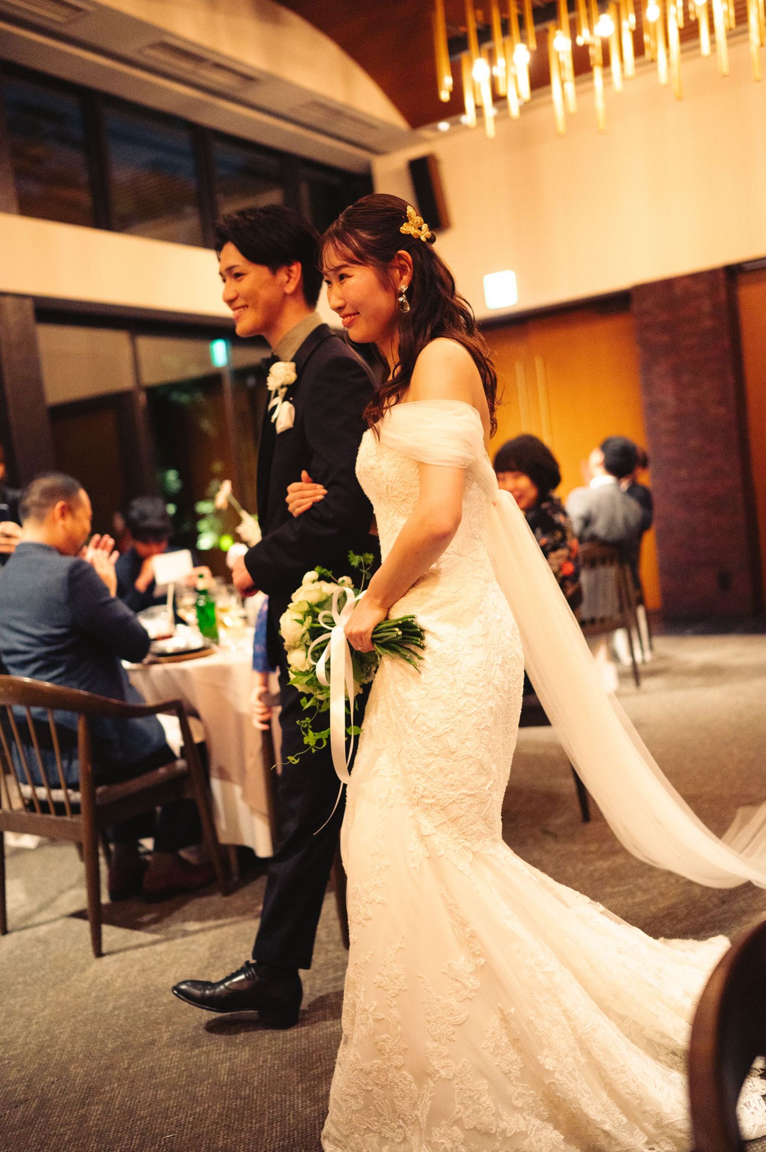 A couple shares a joyful moment during their wedding reception in a beautifully decorated venue.