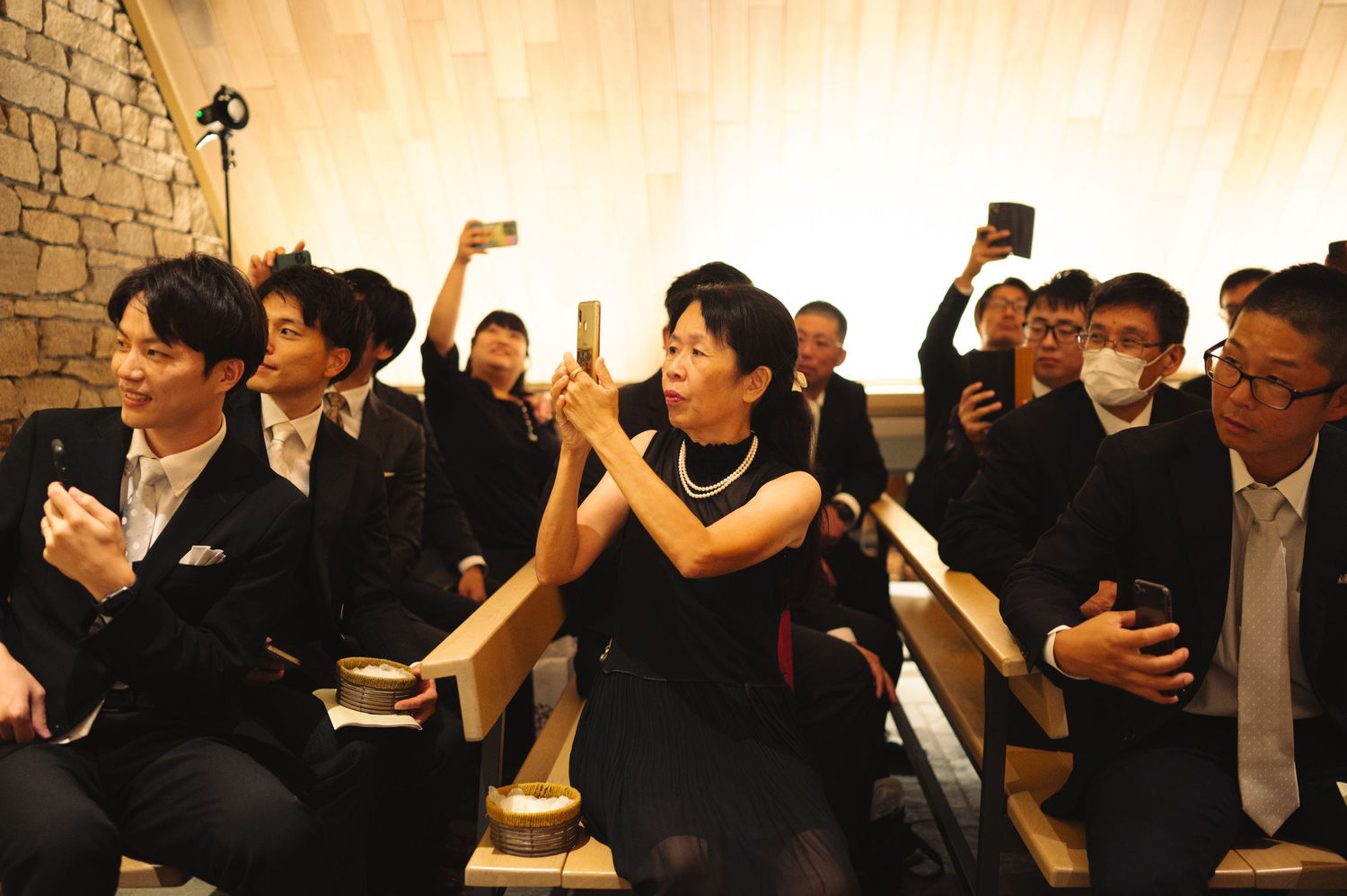 Large group of guests in formal attire participating in an indoor celebration.