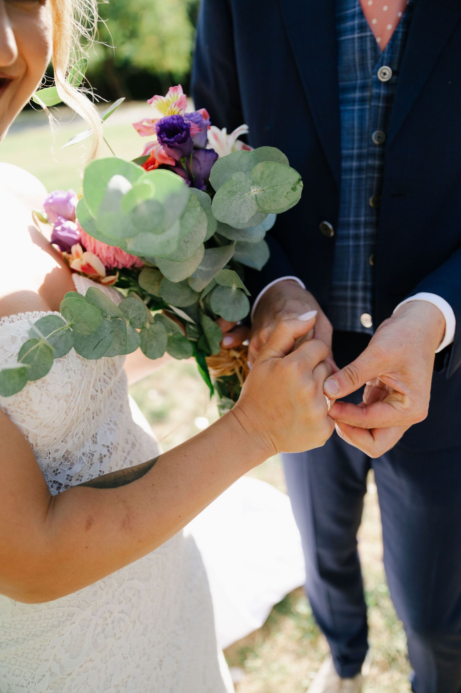 Close-up of wedding bouquet with eucalyptus leaves and colorful flowers.