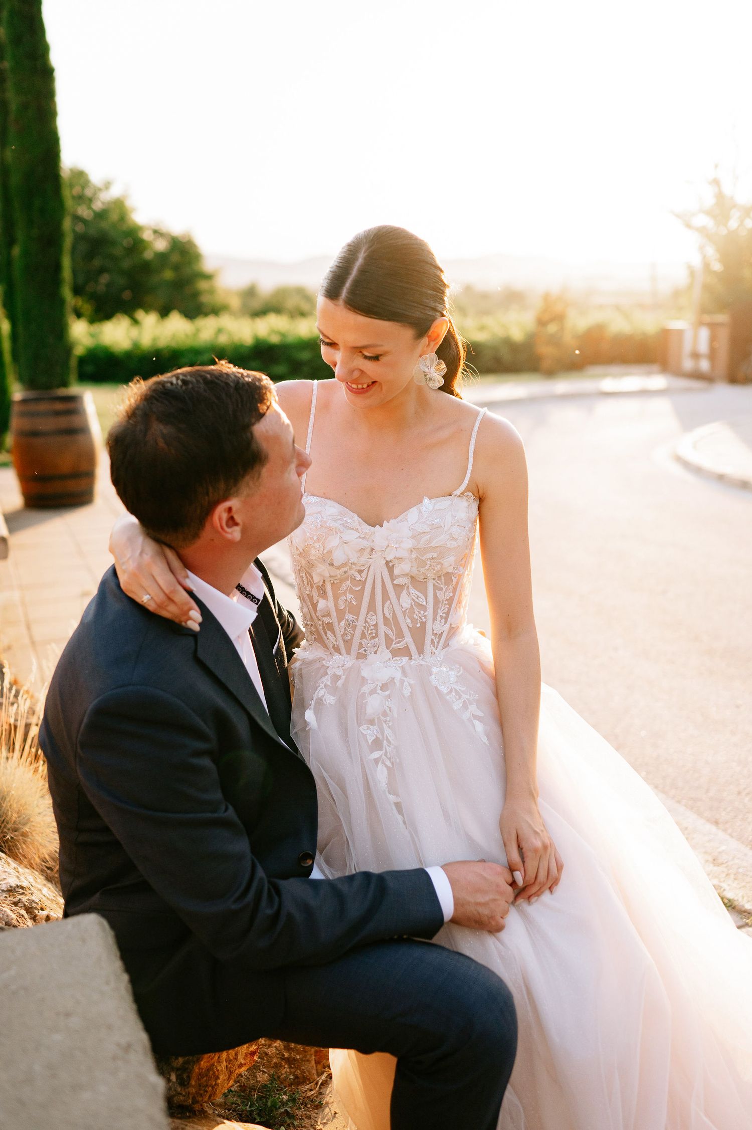 Wedding couple sharing romantic moments on a curved pathway at sunset.