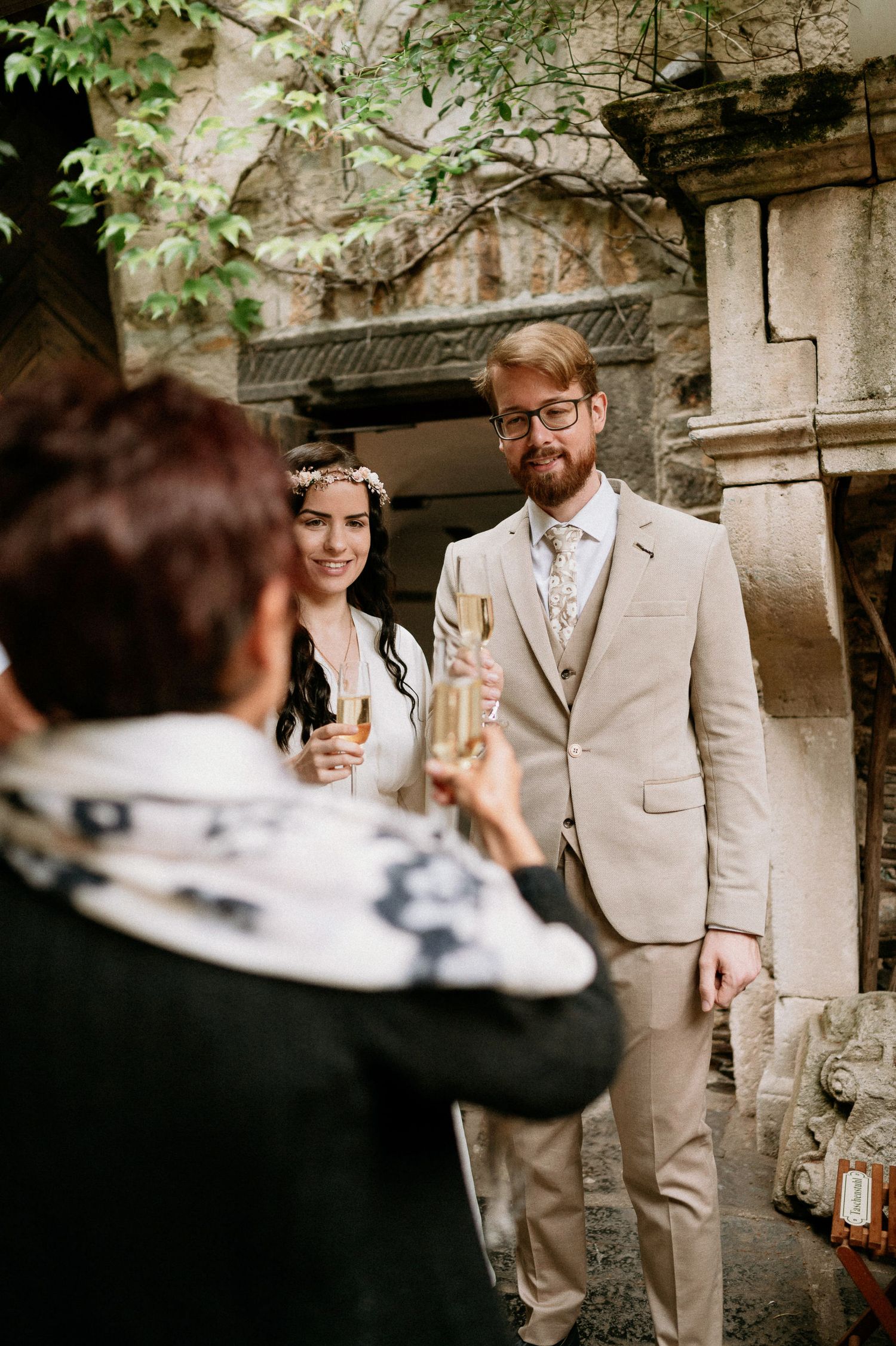 Candid wedding moments captured in a rustic outdoor setting with stone walls.