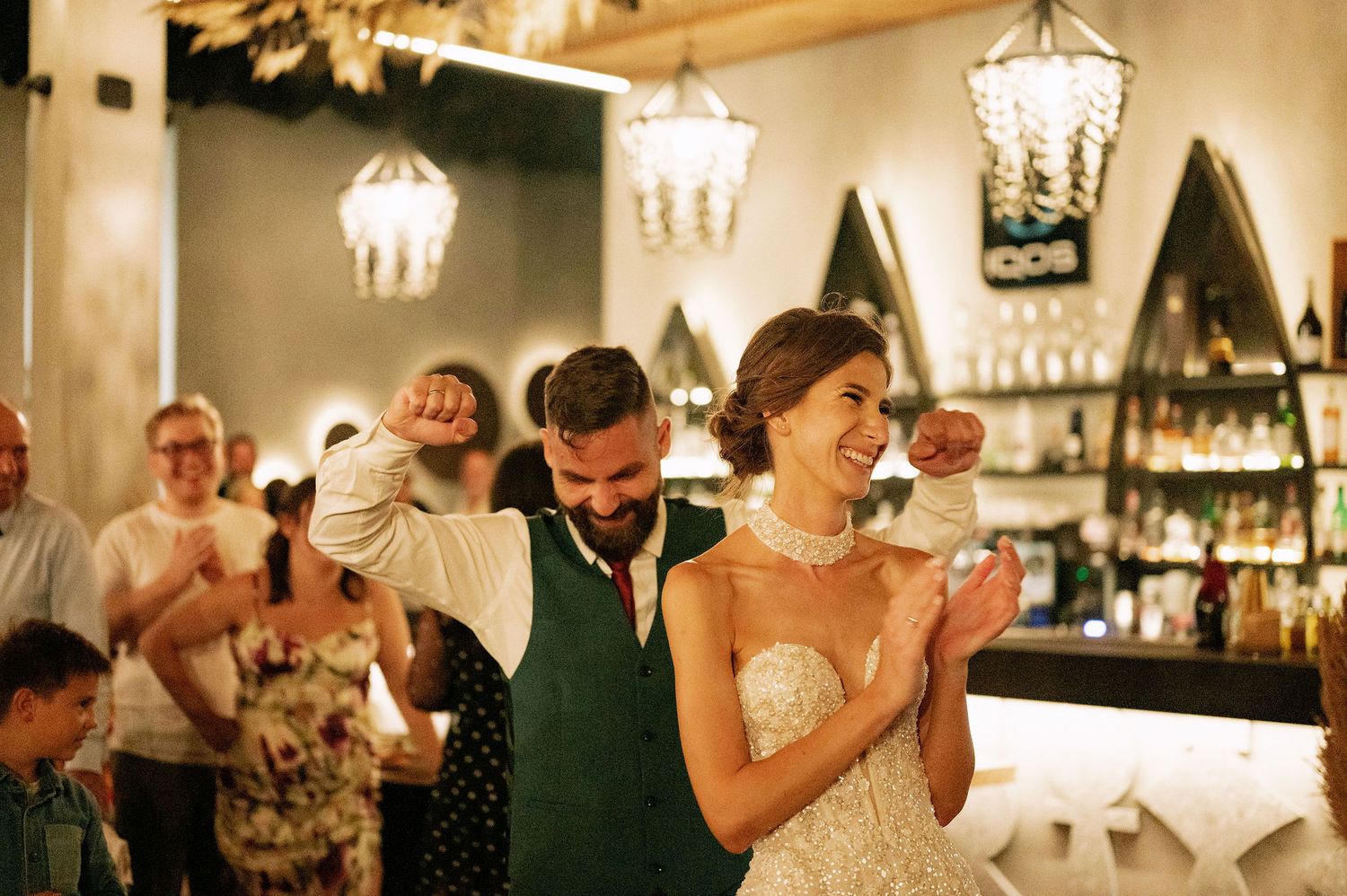 Wedding celebration in a venue decorated with elegant chandeliers and rustic details.