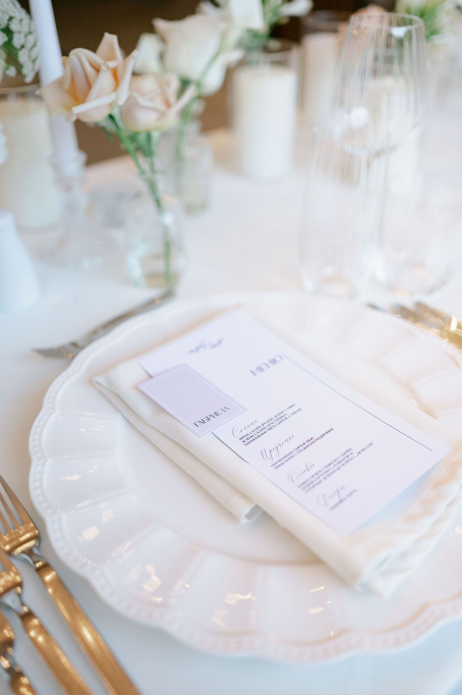 Minimalist white place settings with menu cards and gold cutlery on crisp tablecloths.