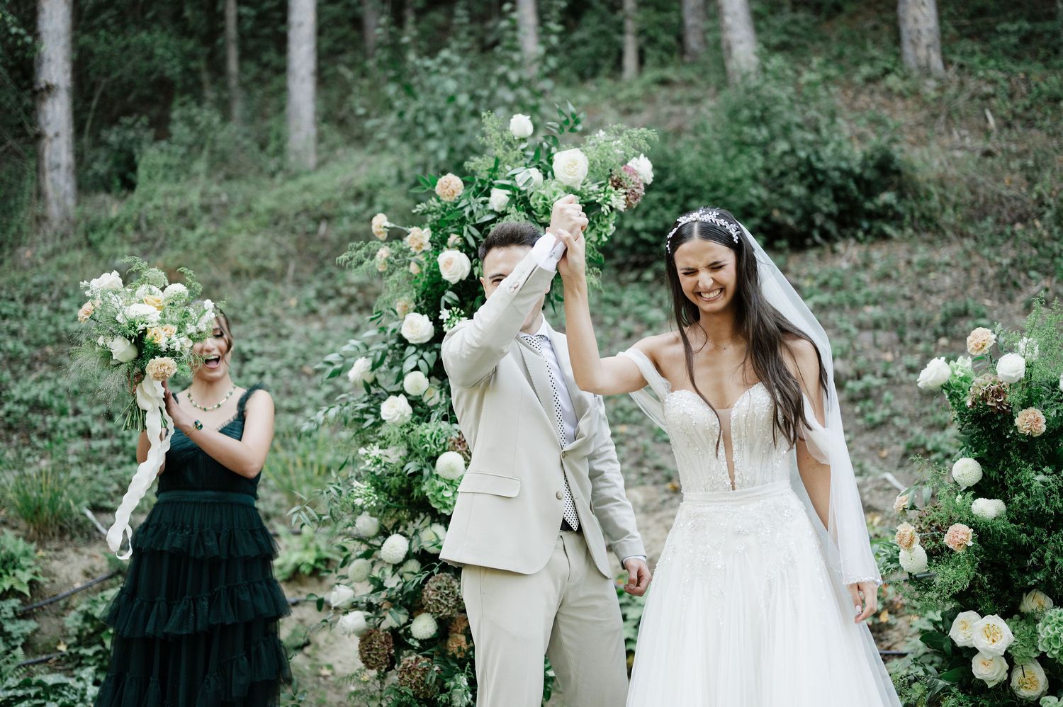 Celebratory moment during woodland wedding with elegant floral decorations.