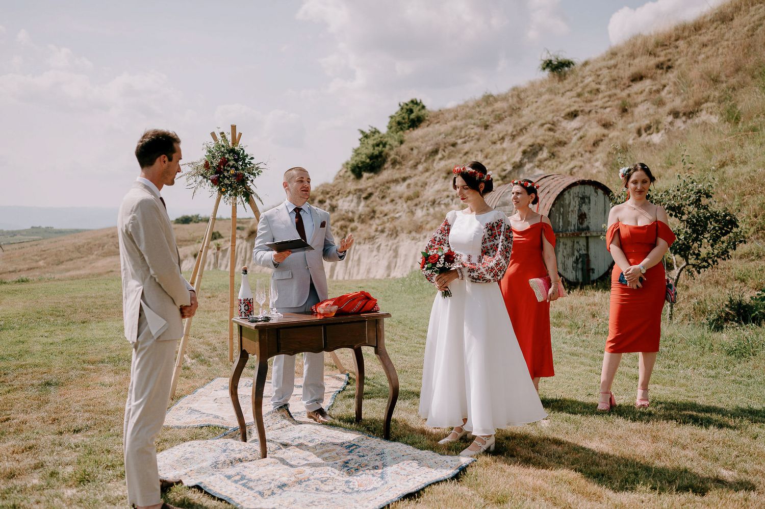 Wedding guests gathered on hillside for outdoor summer ceremony.