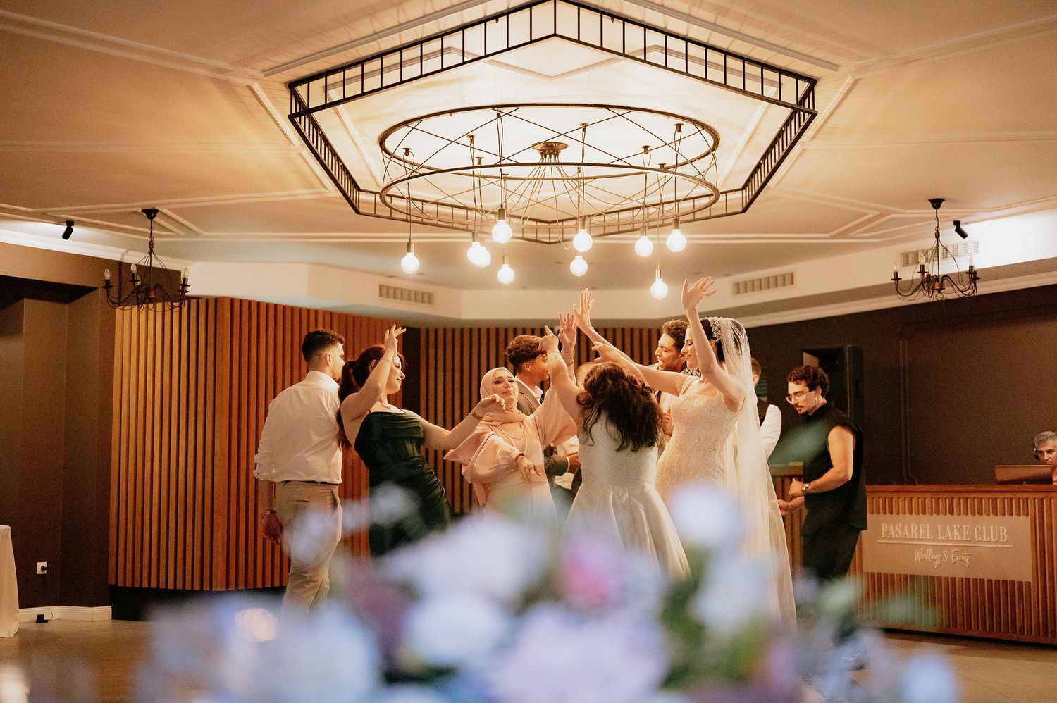 Geometric ceiling design with hanging lights creates an elegant atmosphere in a reception venue.