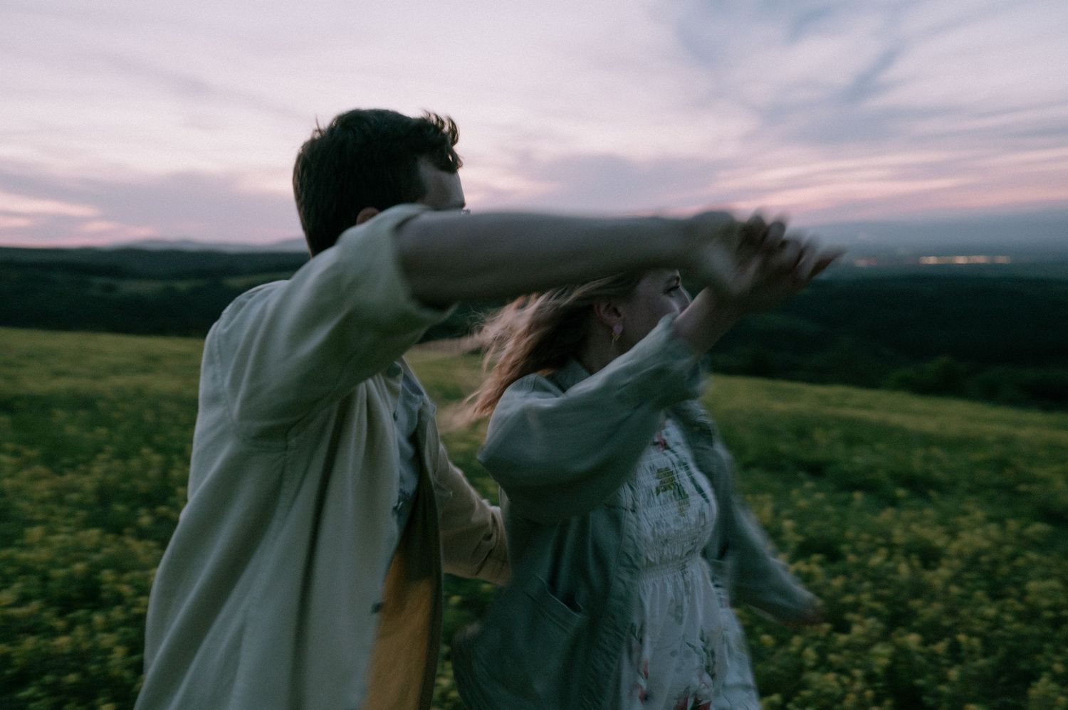 Romantic dance sequence in a flowering meadow at dusk.