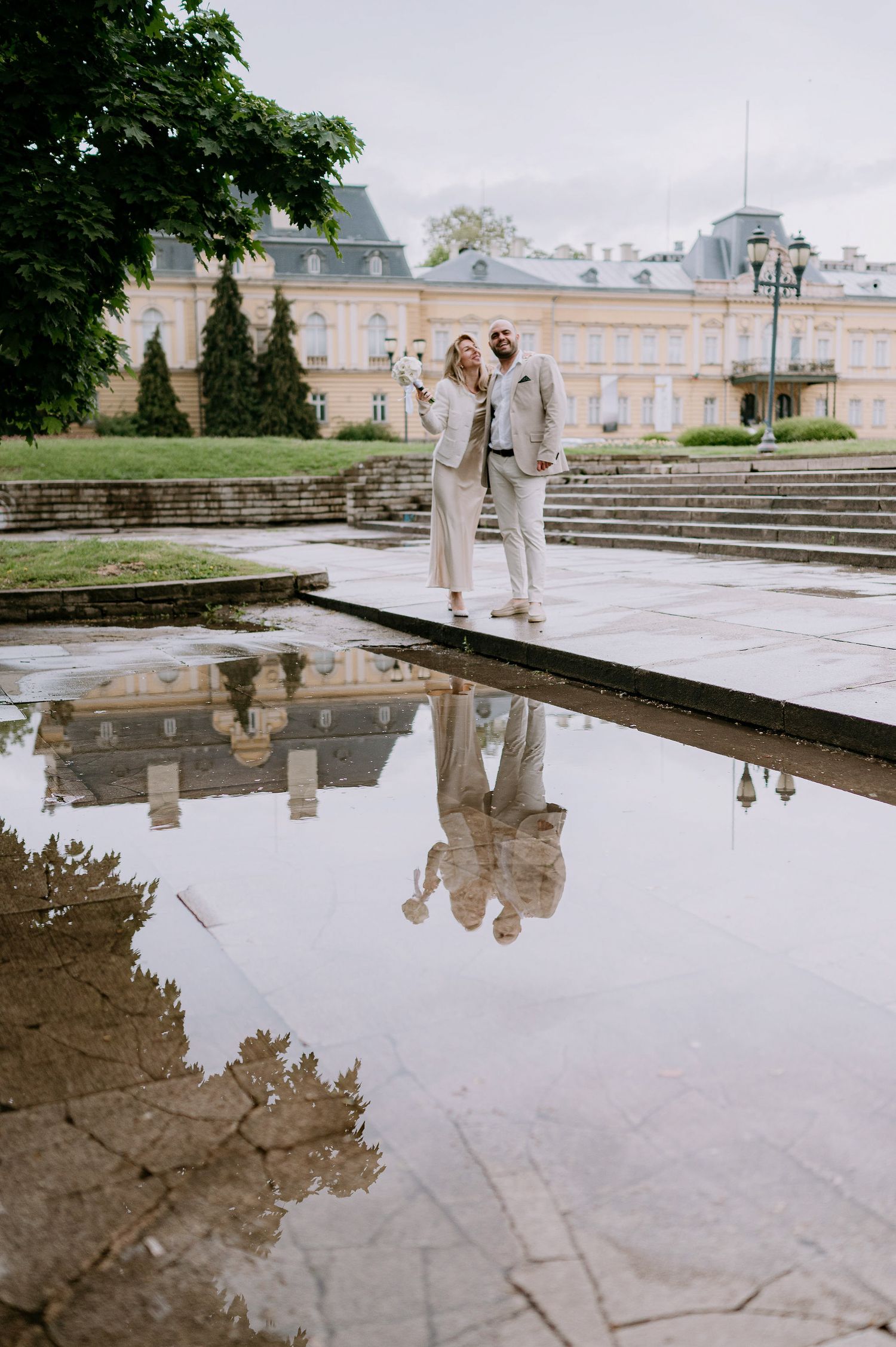 Romantic moment captured with reflections in water at a classical architectural setting.