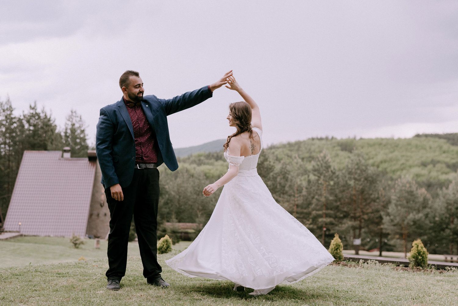 A couple dances together in an outdoor wedding celebration.