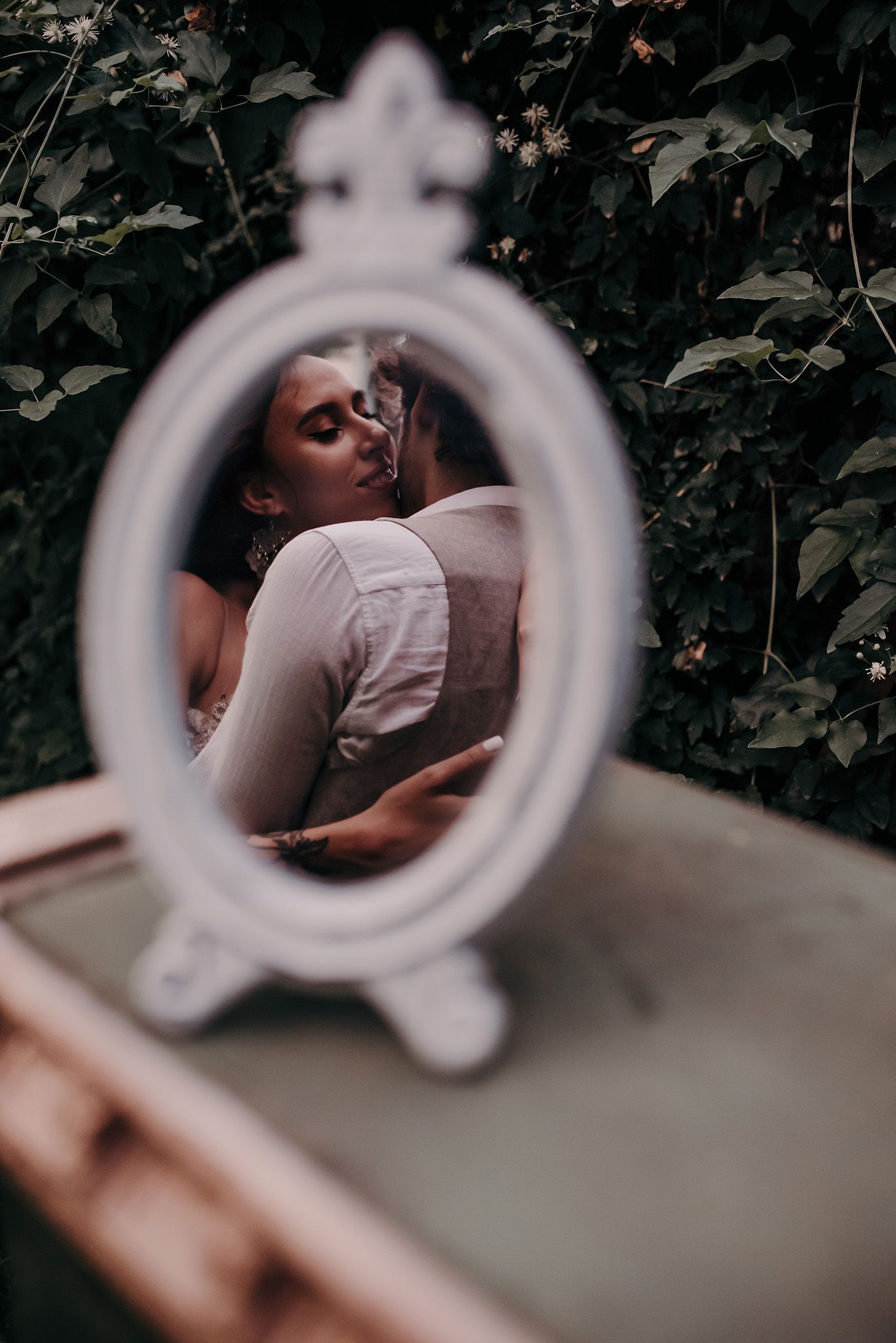 Creative portrait sequence showing blurred circular frames against a dark green leafy background in moody lighting.